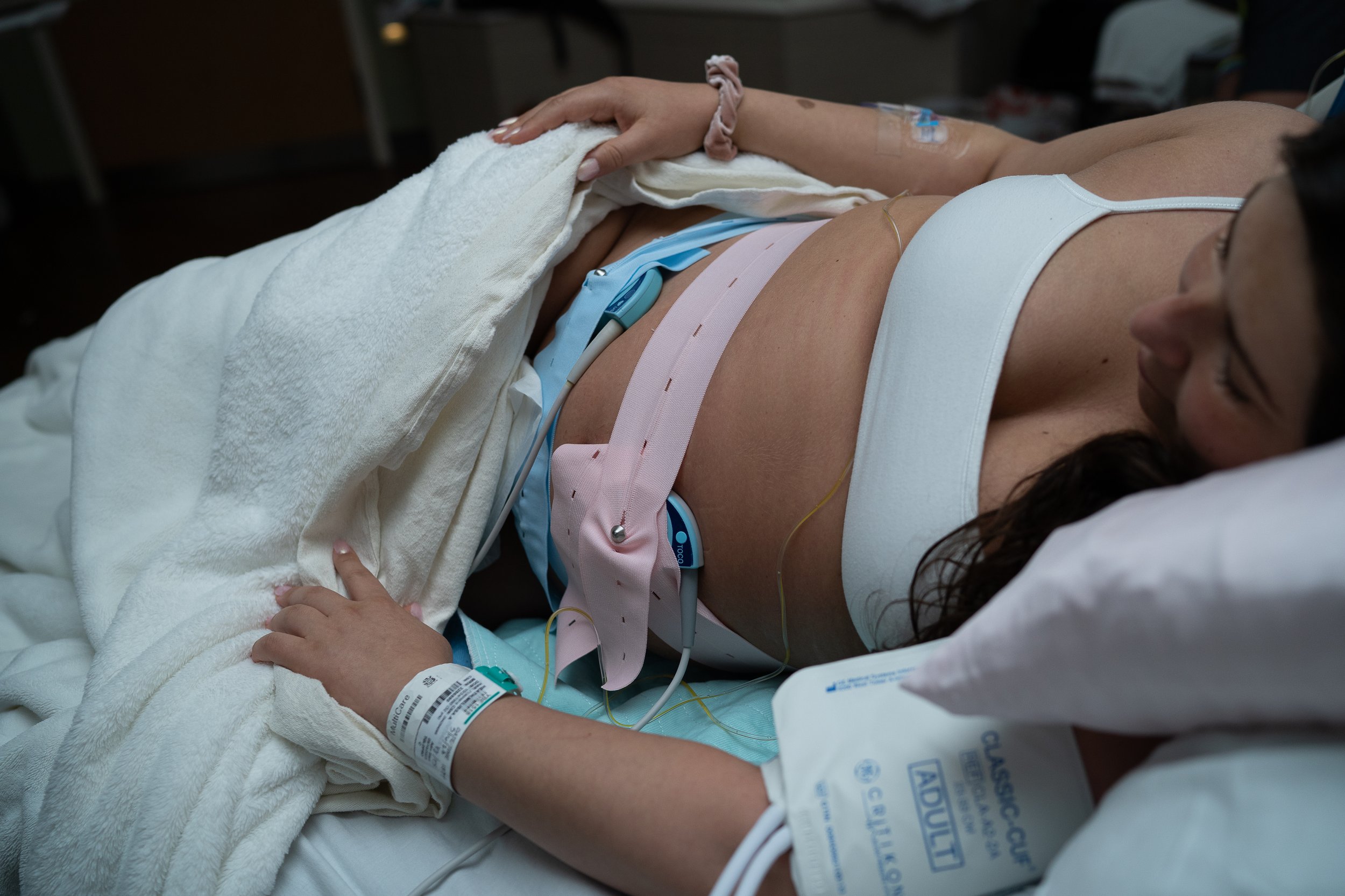 Pregnant woman in Tacoma, WA hospital bed with fetal monitors on her belly.