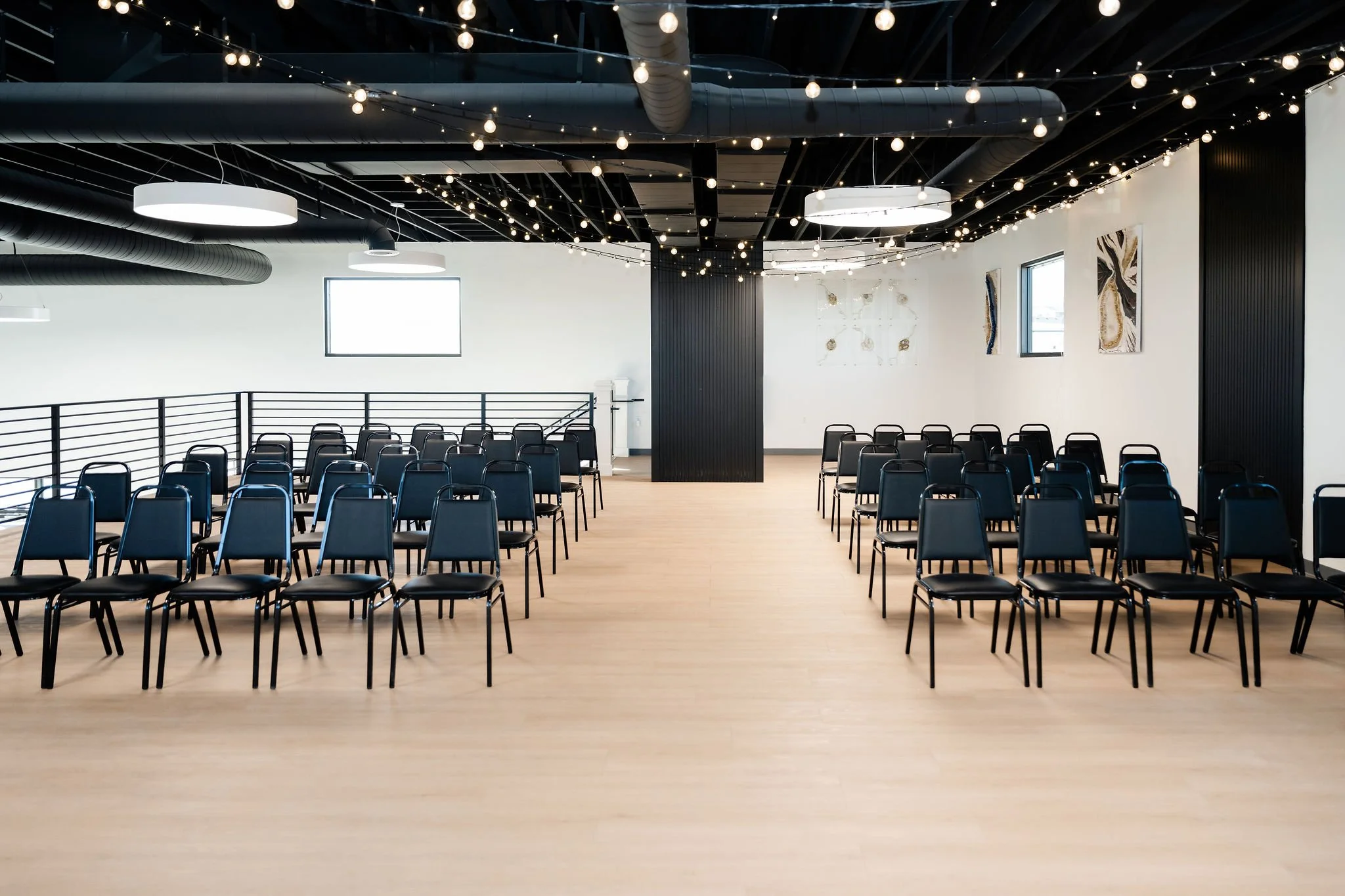 A front view of audience style event seating with hung string lights in our Starlight Loft is a great space for events in Herriman Utah