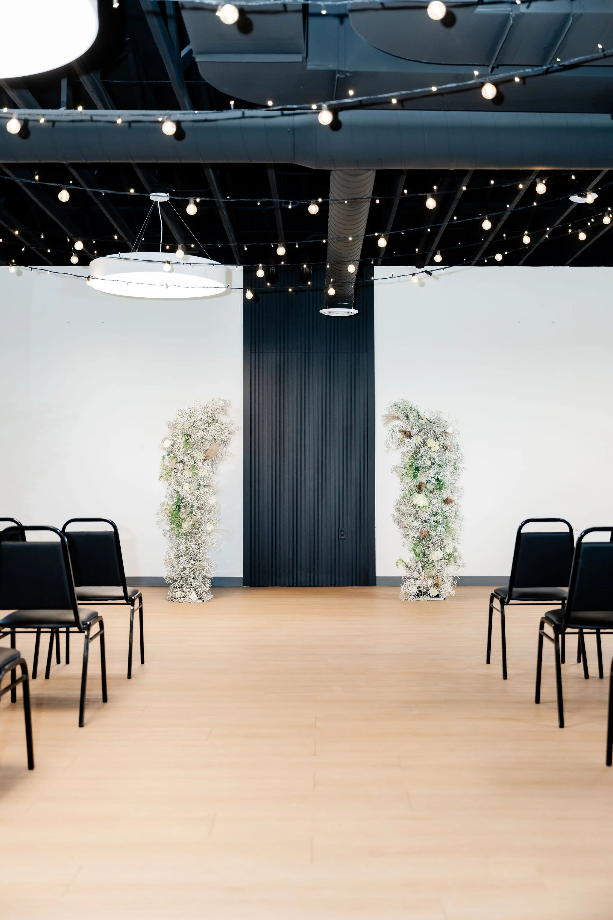 A back view of audience style event seating with hung string lights in our Starlight Loft
