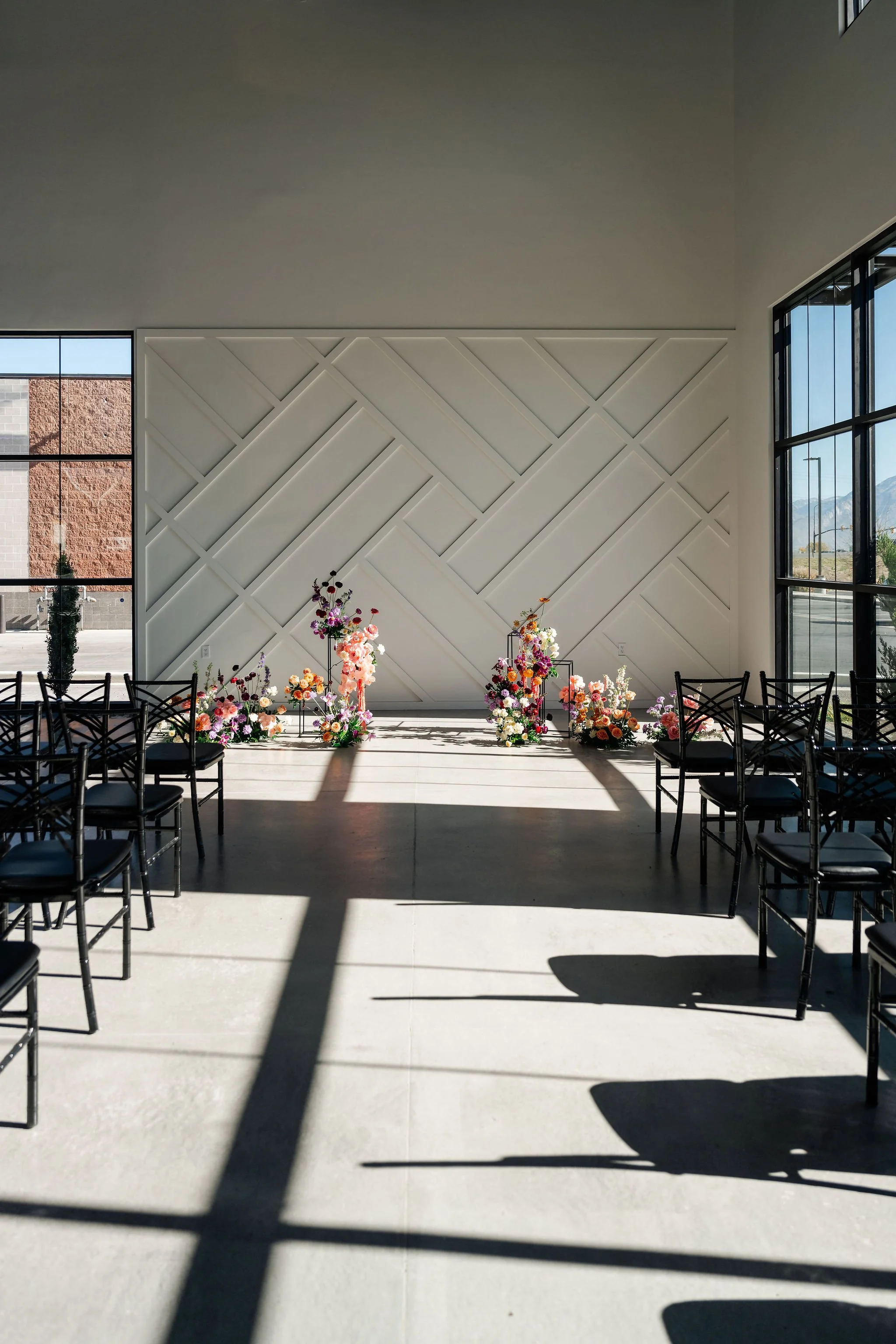 A view of the aisle of ceremony seating with a colorful floral centerpiece at the head in our Enchanted Hall