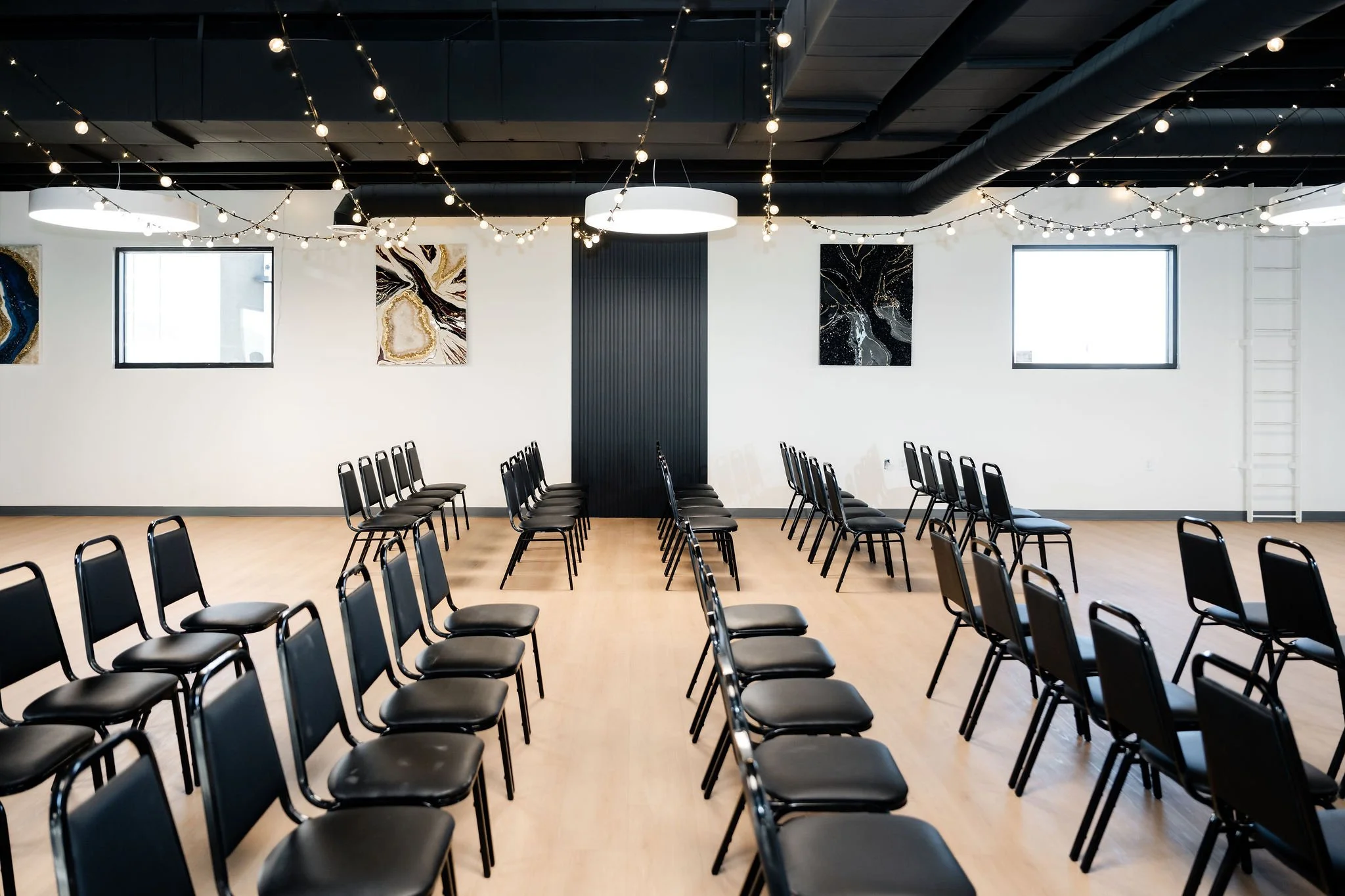 A side view of audience style event seating with hung string lights in our Starlight Loft
