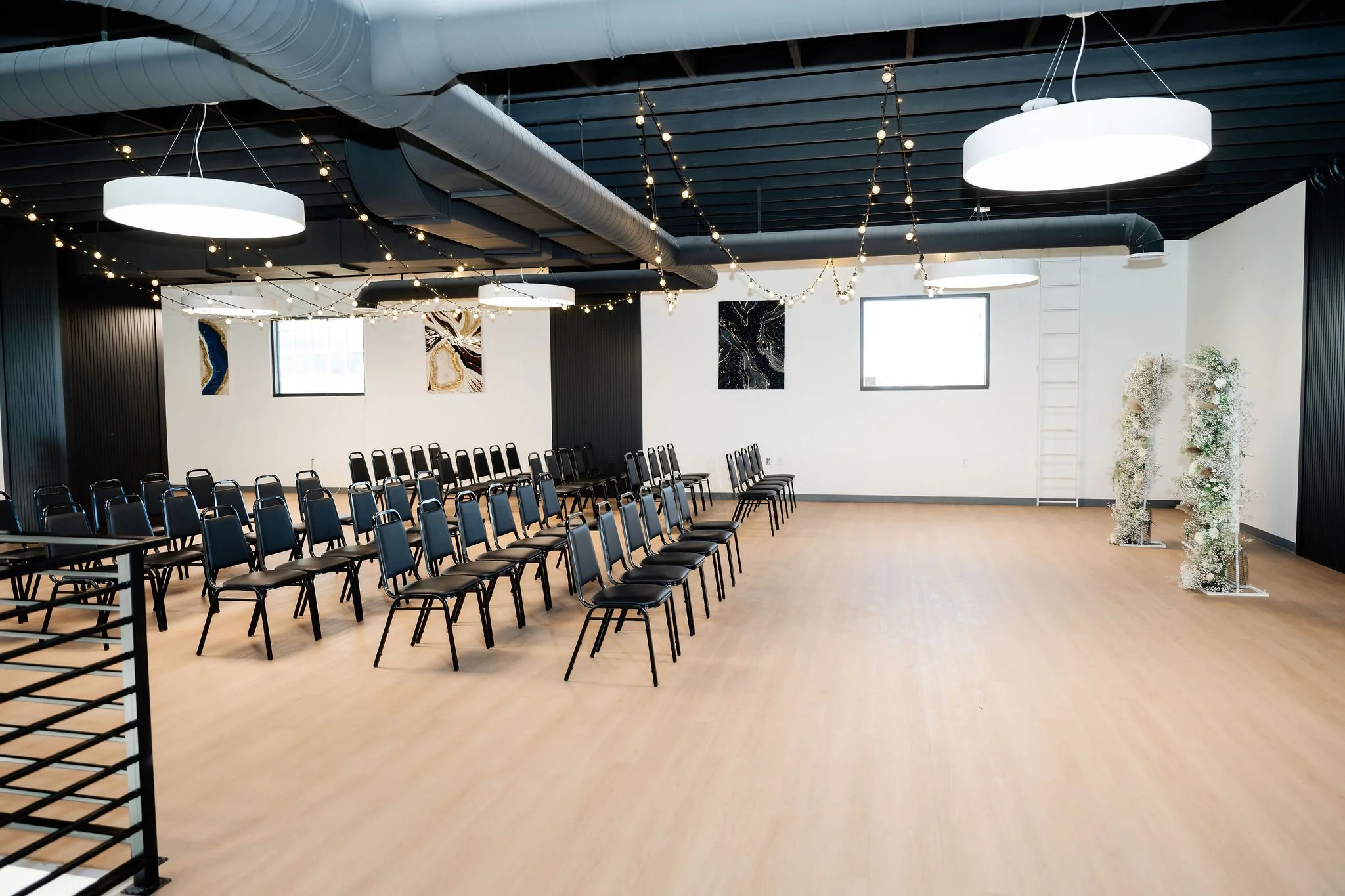 A side view setup for a wedding even in our Starlight Loft with a floral aisle centerpiece and hung lighting