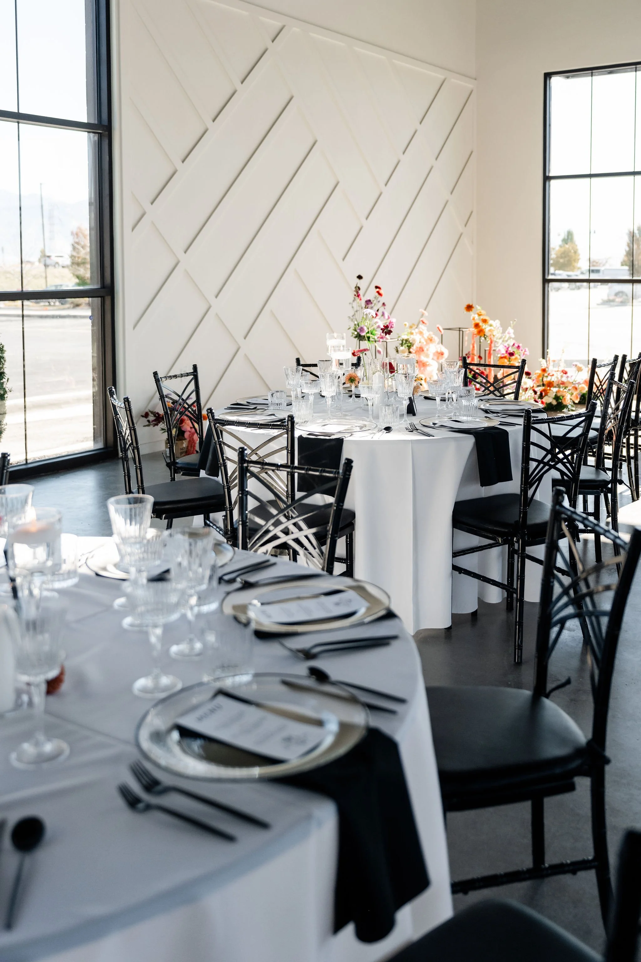 Elegant dining seating with a floral ceremony center in the background