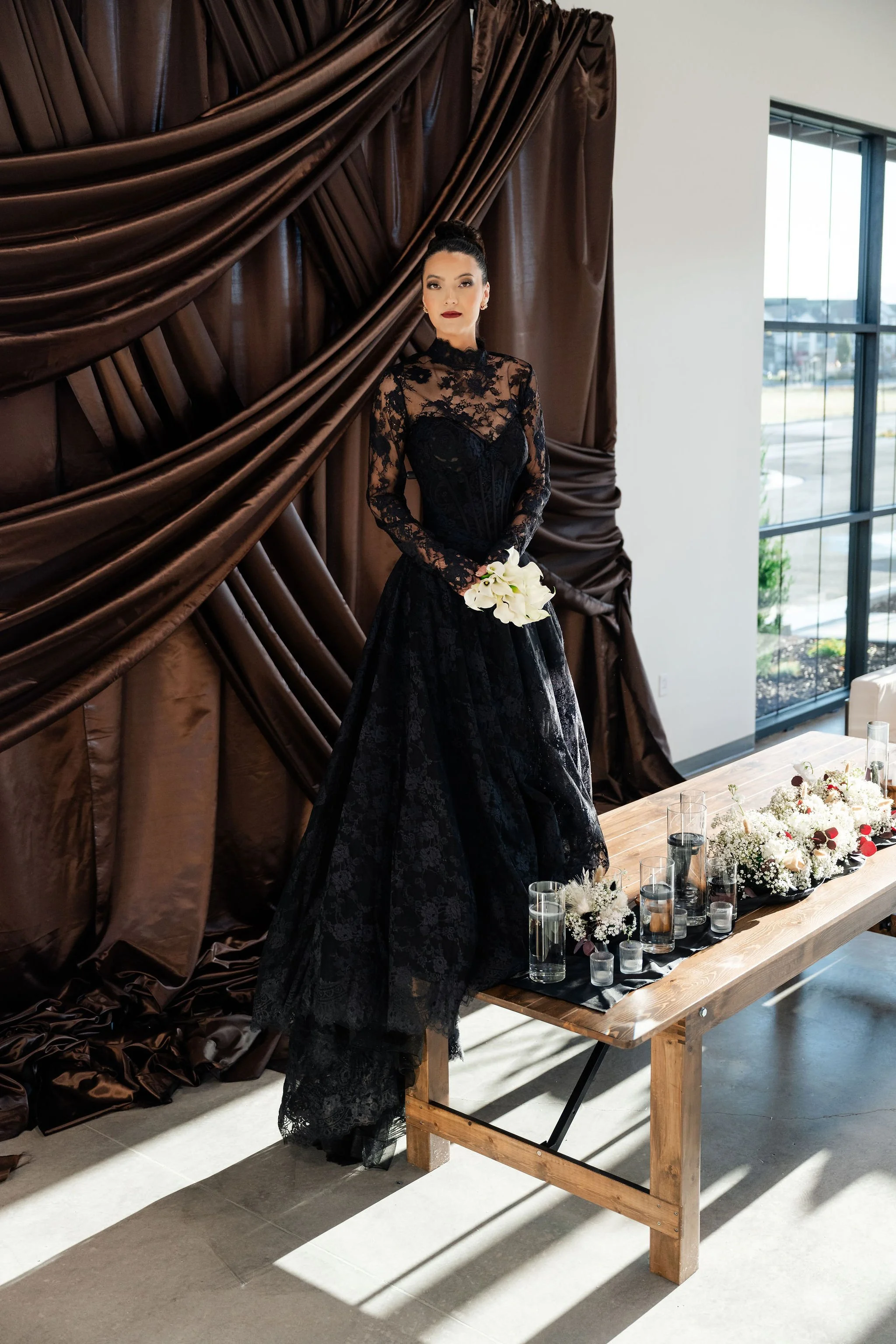 A bride in black wedding dress with a brown backdrop in our main hall, also known as the Enchanted Hall