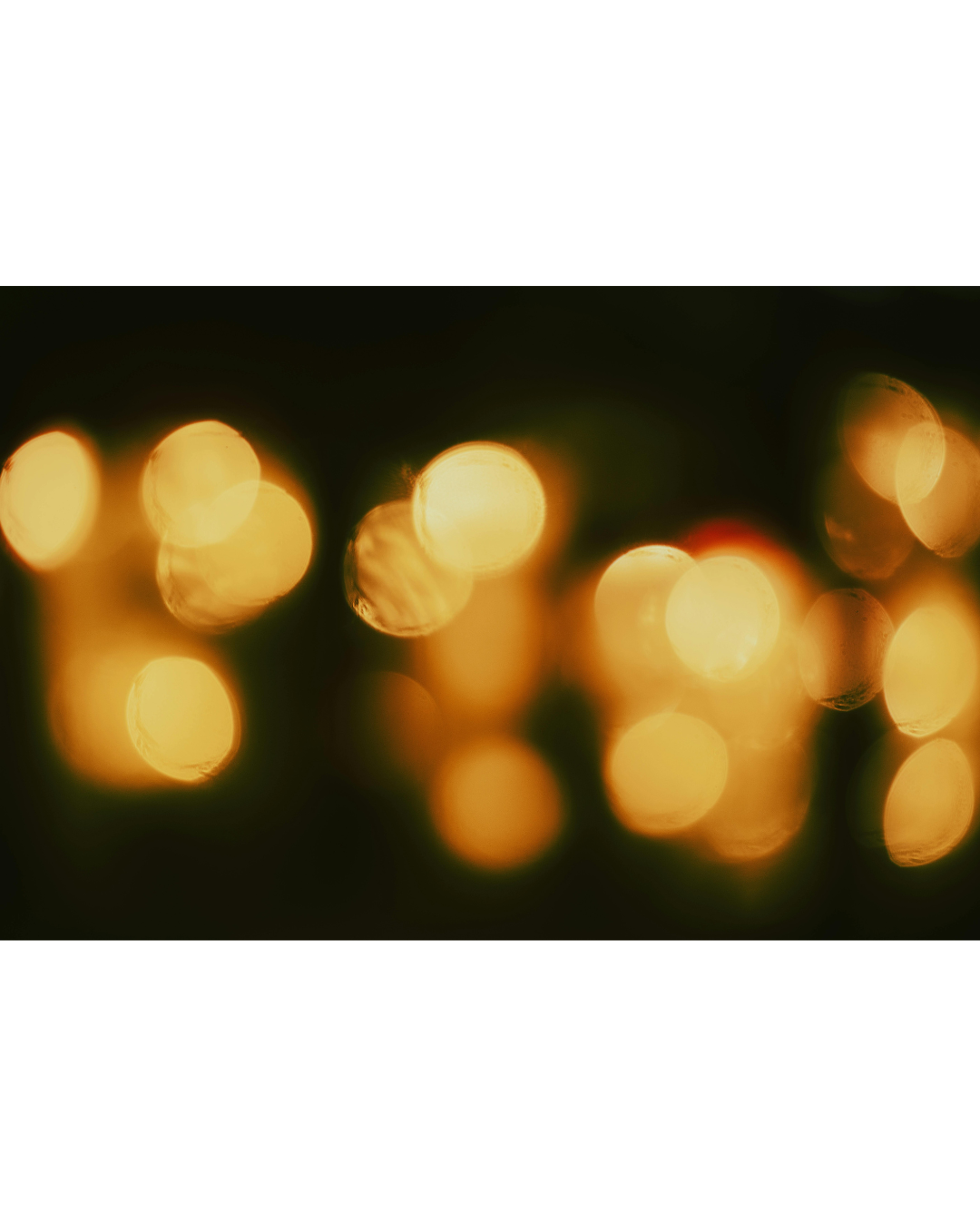 Blurred golden lights against a dark background, creating a bokeh effect.