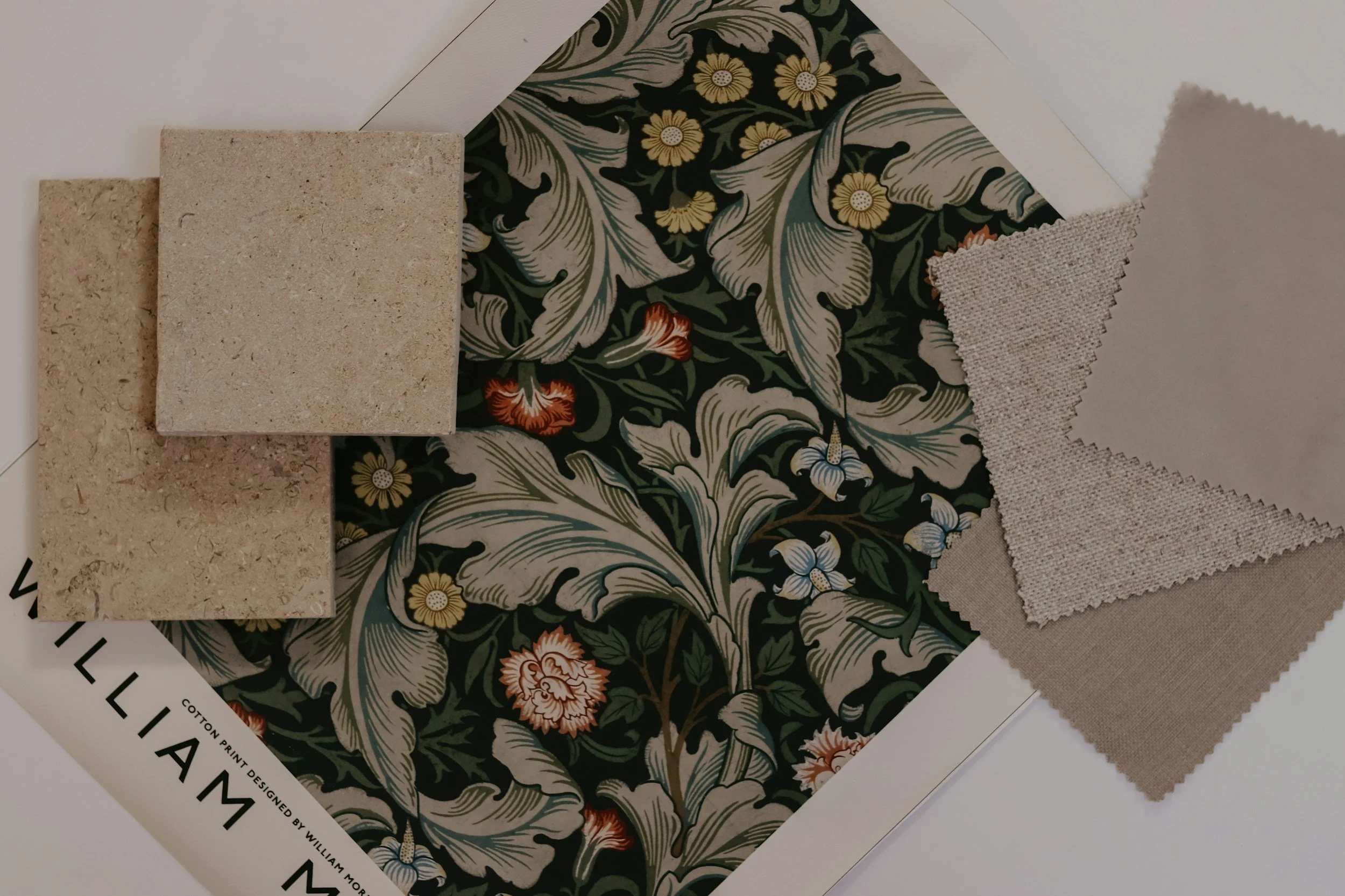 Fabric with floral pattern, sample tiles, and fabric swatches for event decor.