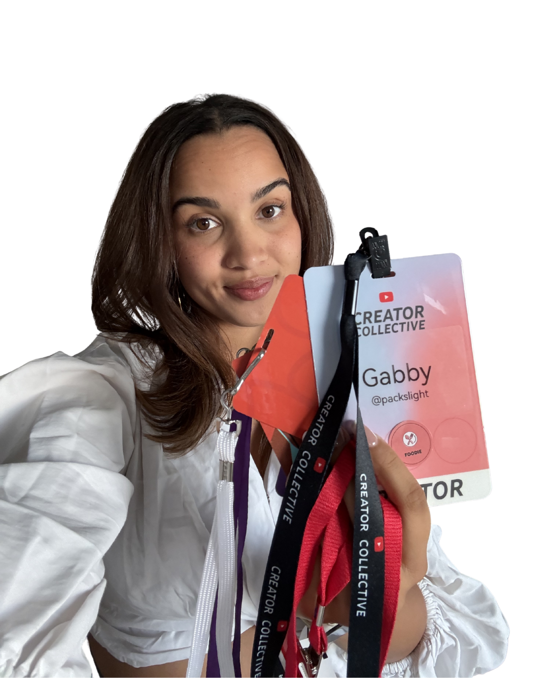 Young woman (Gabby Beckford) with brown hair holding a name badge and NYC influencer event lanyards, smiling, with a black background.