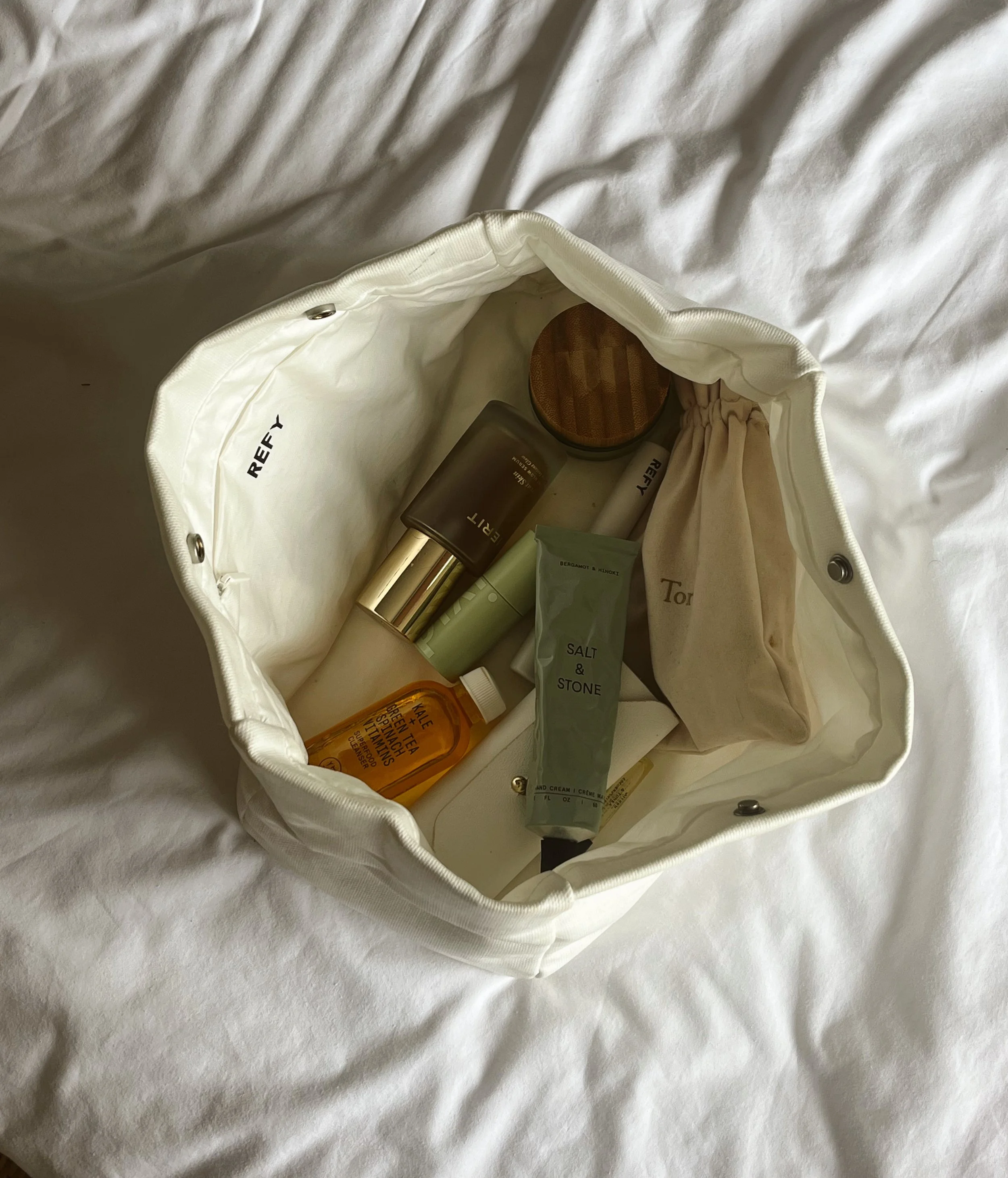 Refy skincare. Open white bag with various skincare and personal care products inside, placed on a white surface.