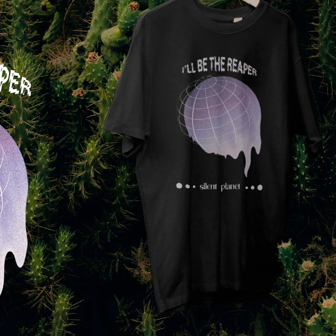 T-shirt noir avec un graphique de planète en dégradé violet et blanc, texte 'I'll be the reaper', arrière-plan de cactus.