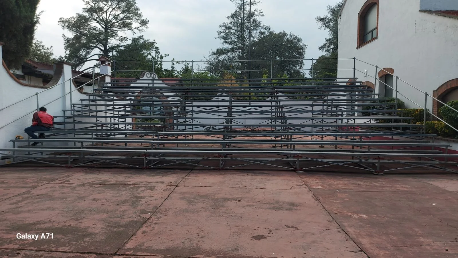 Personas montando y ajustando graderías metálicas en un espacio al aire libre