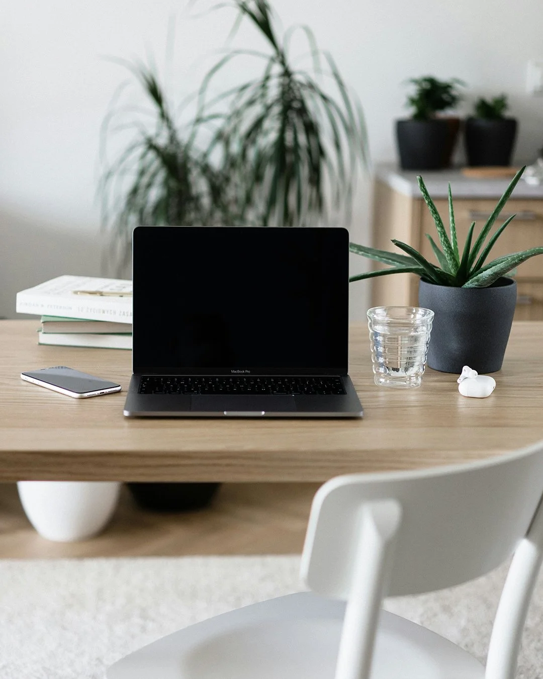 A laptop sitting on a wooden desk in a bright office space