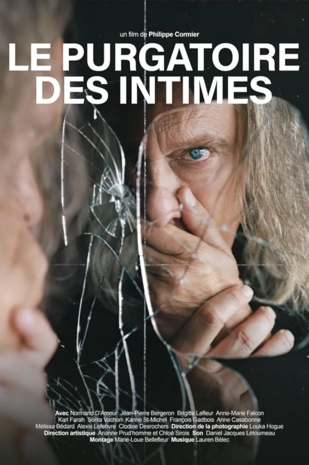 Premier plan d'une femme regardant dans un miroir fissuré, reflet montrant une vieille femme avec des cheveux gris et une main sur son visage.