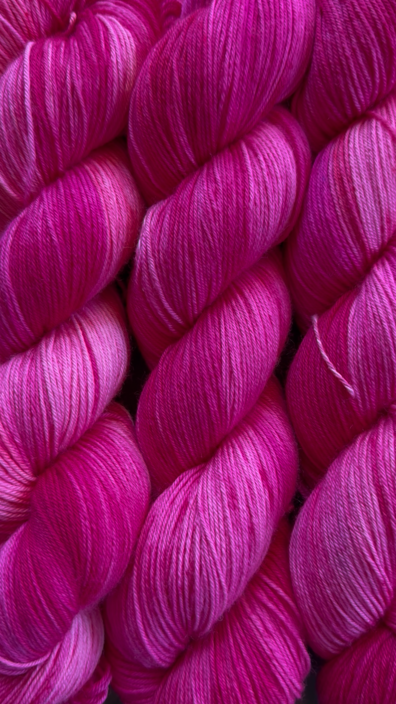 Close-up of several skeins of bright pink yarn intertwined.