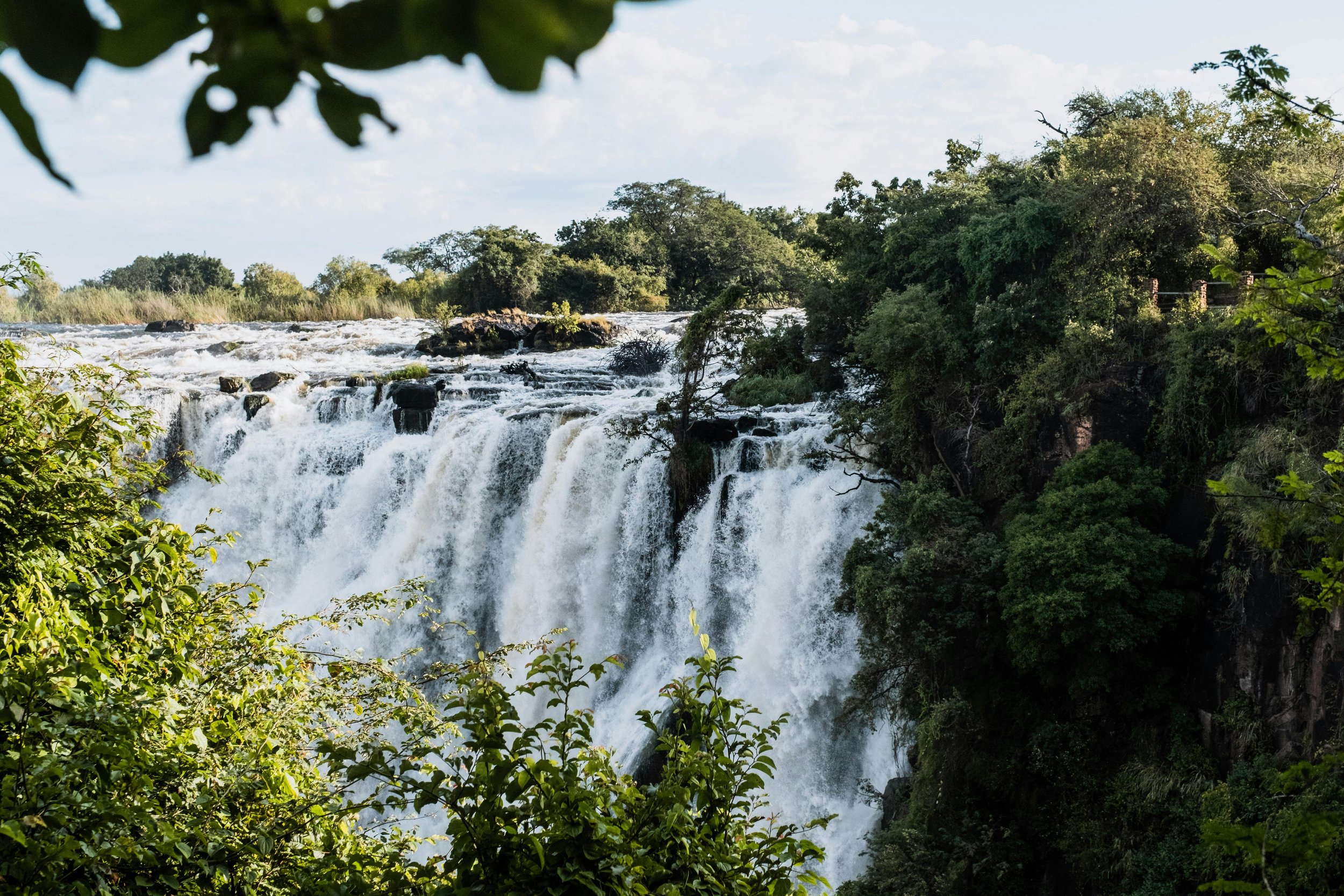 Panoramic view of Victoria Falls thundering into gorge during peak rainy season in Southern Africa