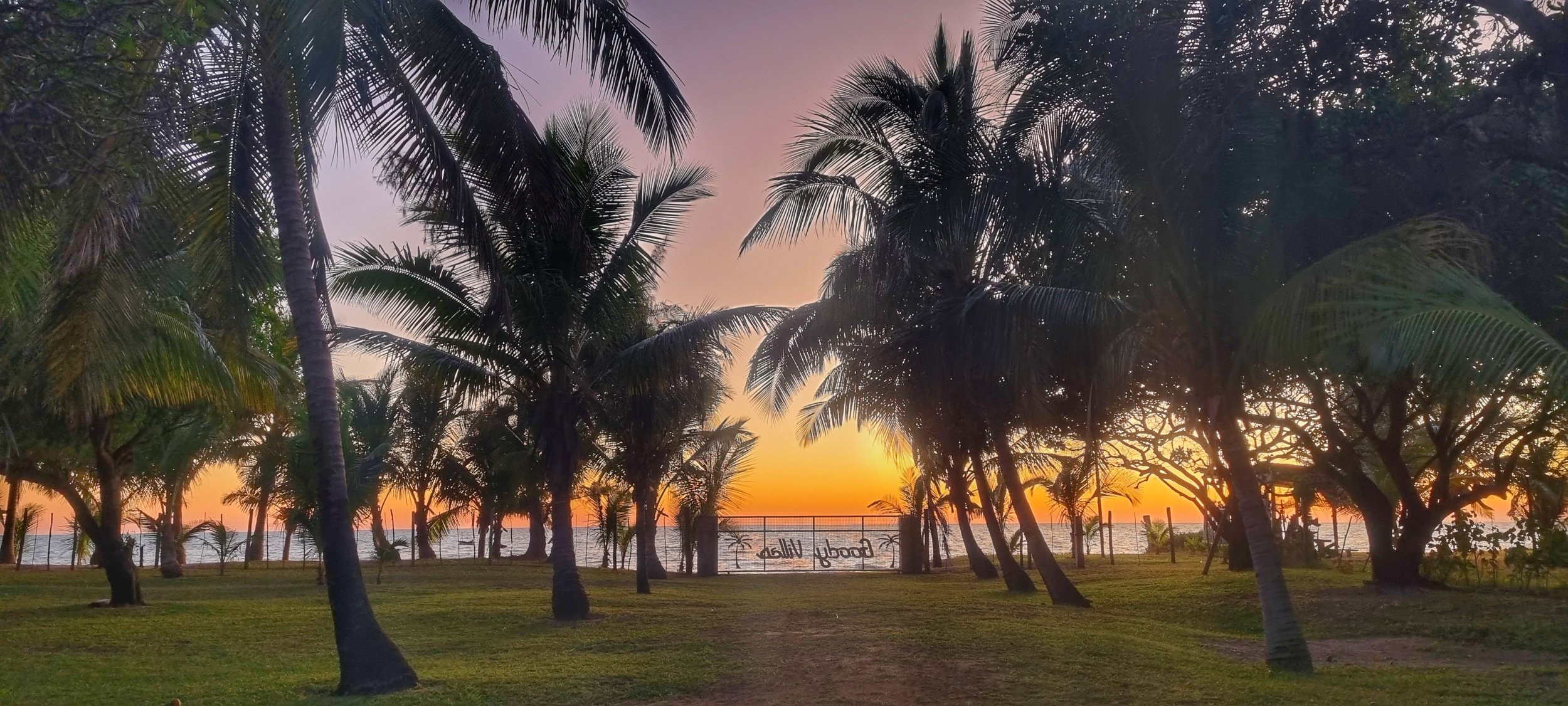 Palm trees frame a golden sunset on Mozambique’s coast
