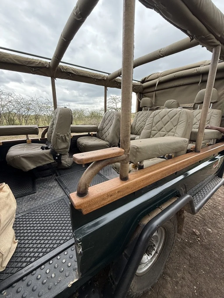 Safari vehicle driving through African savannah on wildlife tour