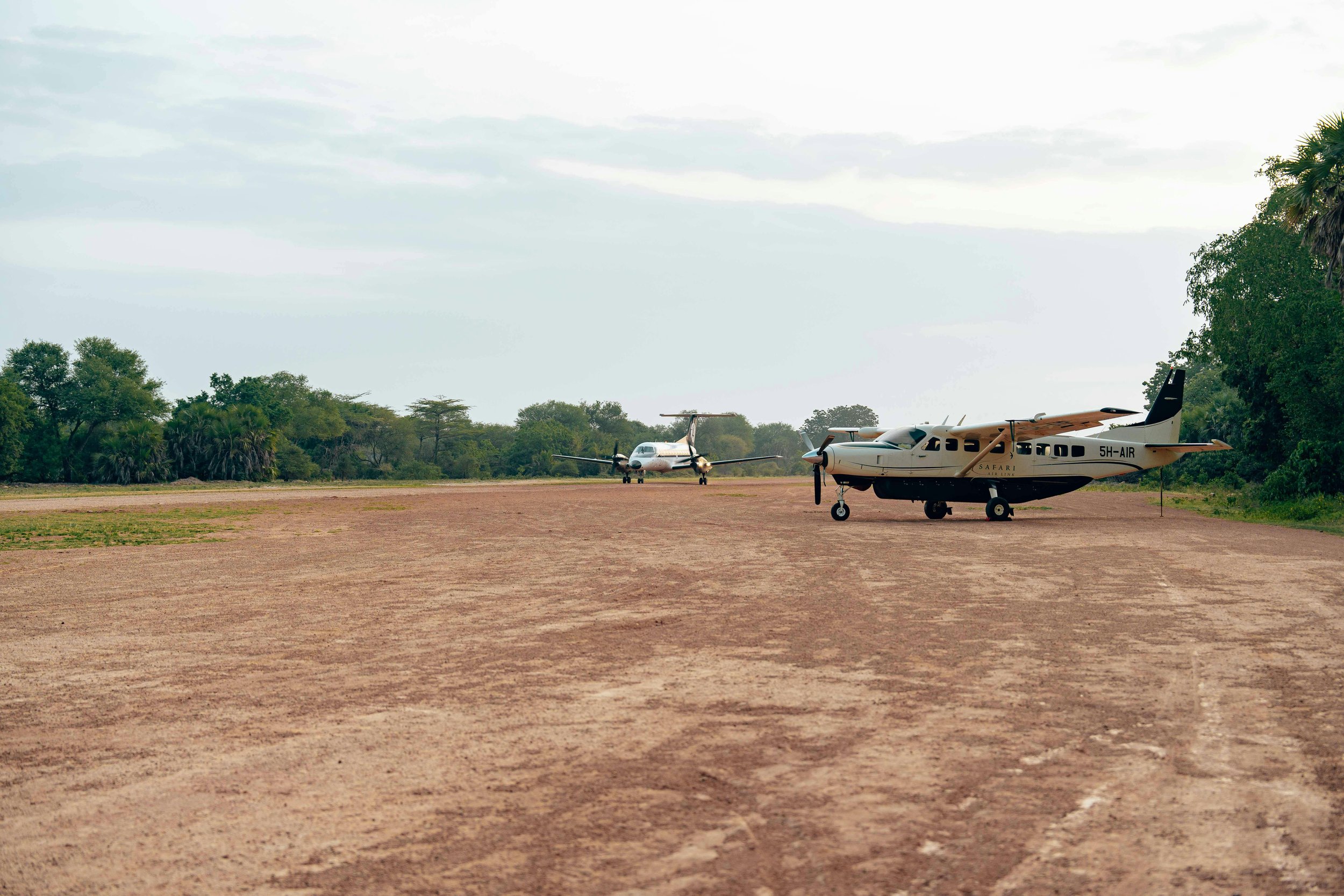 Light aircraft on a remote savanna airstrip in Africa, offering scenic fly-in safari access to wildlife-rich national parks and exclusive lodges