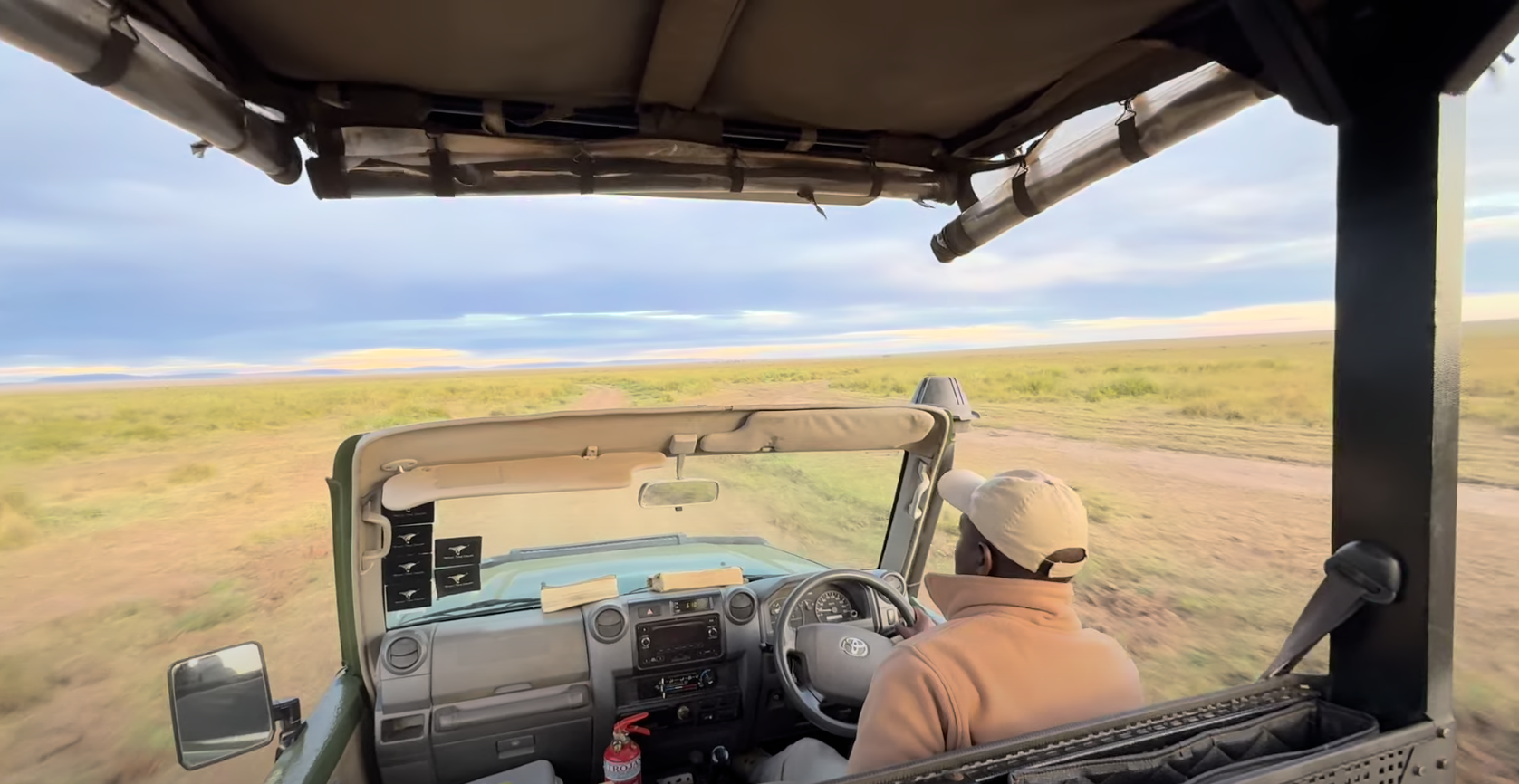 Safari guide driving 4x4 vehicle through African savannah, leading travellers on wildlife adventure