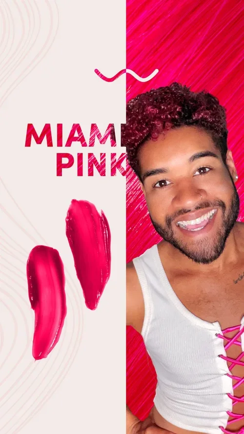 A smiling man with short curly hair and a beard, wearing a white tank top with pink laces, stands in front of a split pink and white background with the words 'Miami Pink' and two pink brushstroke marks.