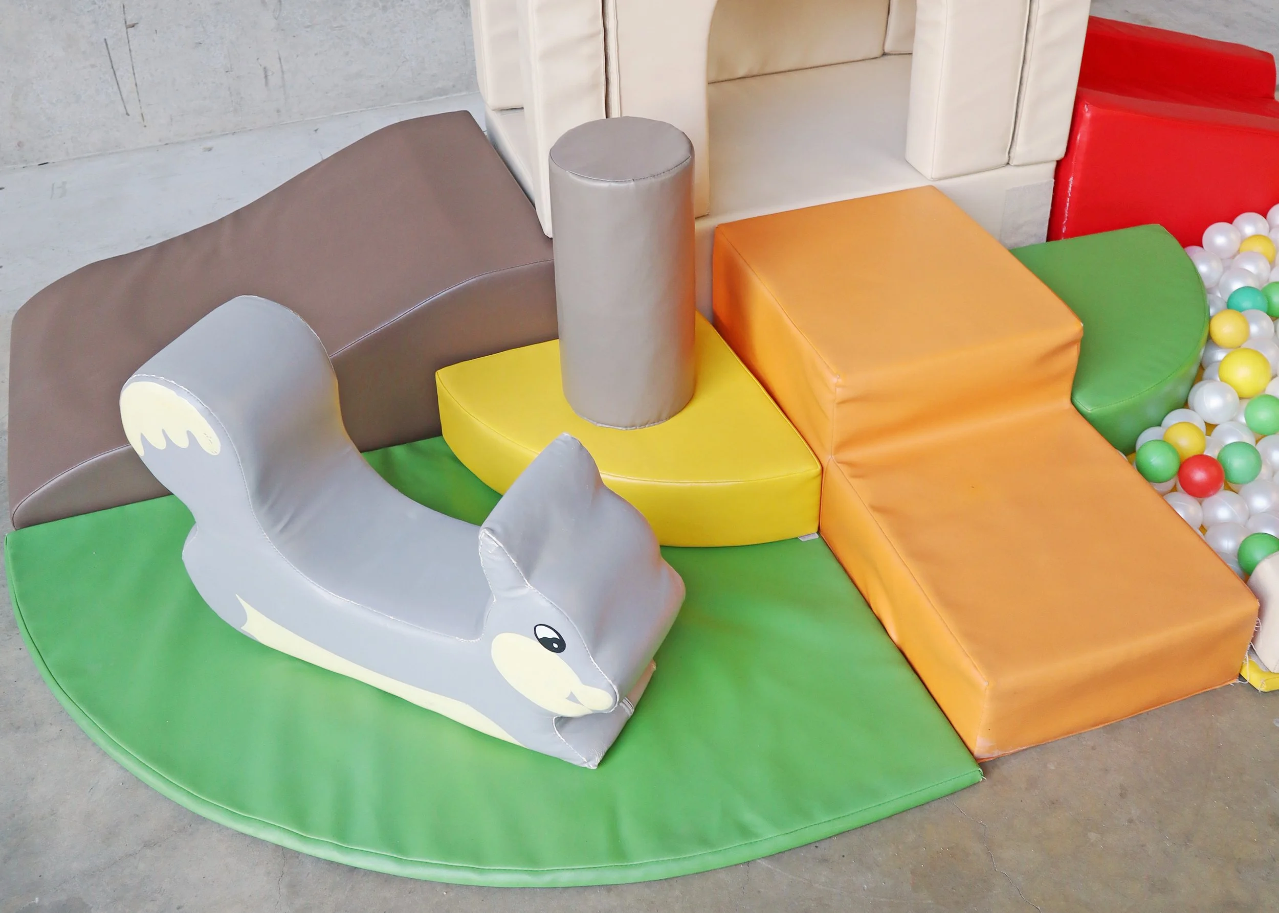 Colorful indoor play area with soft foam blocks and a ball pit with plastic balls.