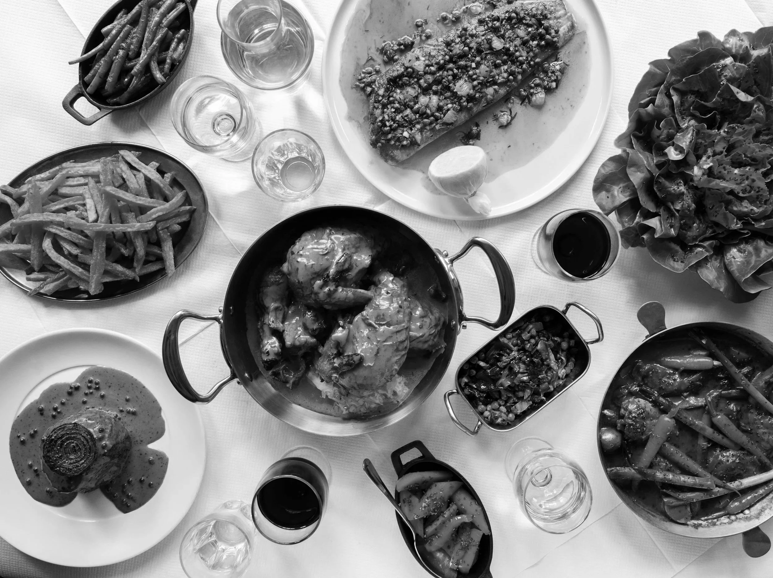 A table set with plates of French fries, salad, and bread rolls, along with glasses of water and red wine. Some of the coverage Amy Williams Food & Drink PR Consultancy has achieved in National Press