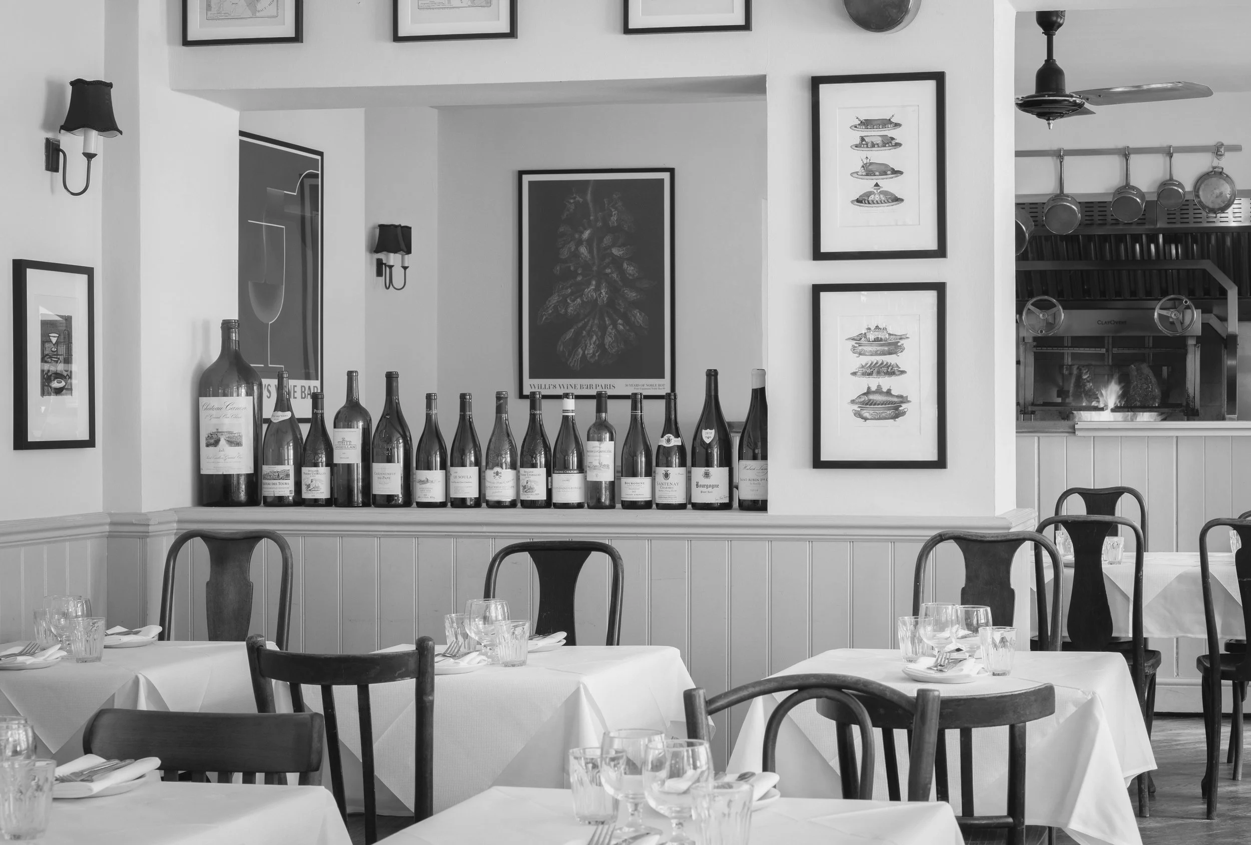 Interior of a restaurant with tables covered in white tablecloths, set with glasses and utensils. An example of an Amy Williams Hospitality Public Relations Client in London
