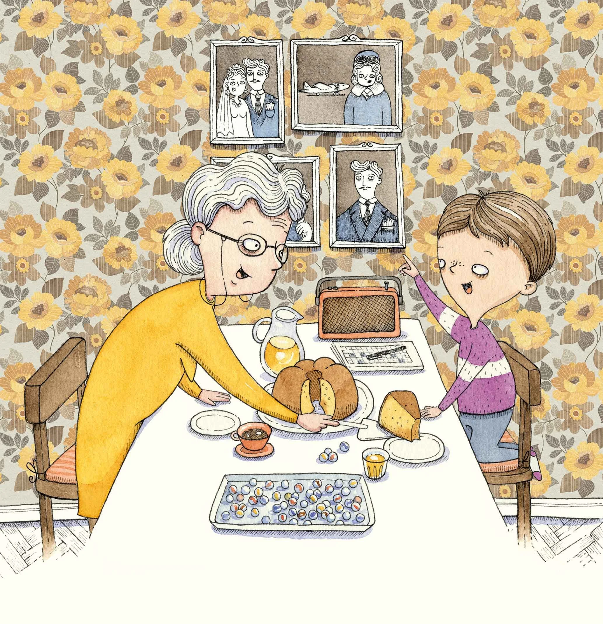A grandmother and a young boy sitting at a dining table with birthday cake, drinks, and snacks, celebrating a birthday with pictures of family members on the wall in the background.
