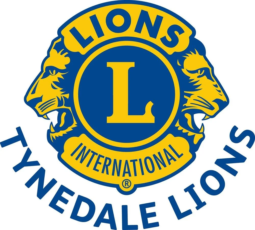Lions International logo with two yellow lions facing away from each other on a blue shield, with a yellow banner reading 'Lions' and 'International,' and blue text 'Tyne Dale Lions' underneath.