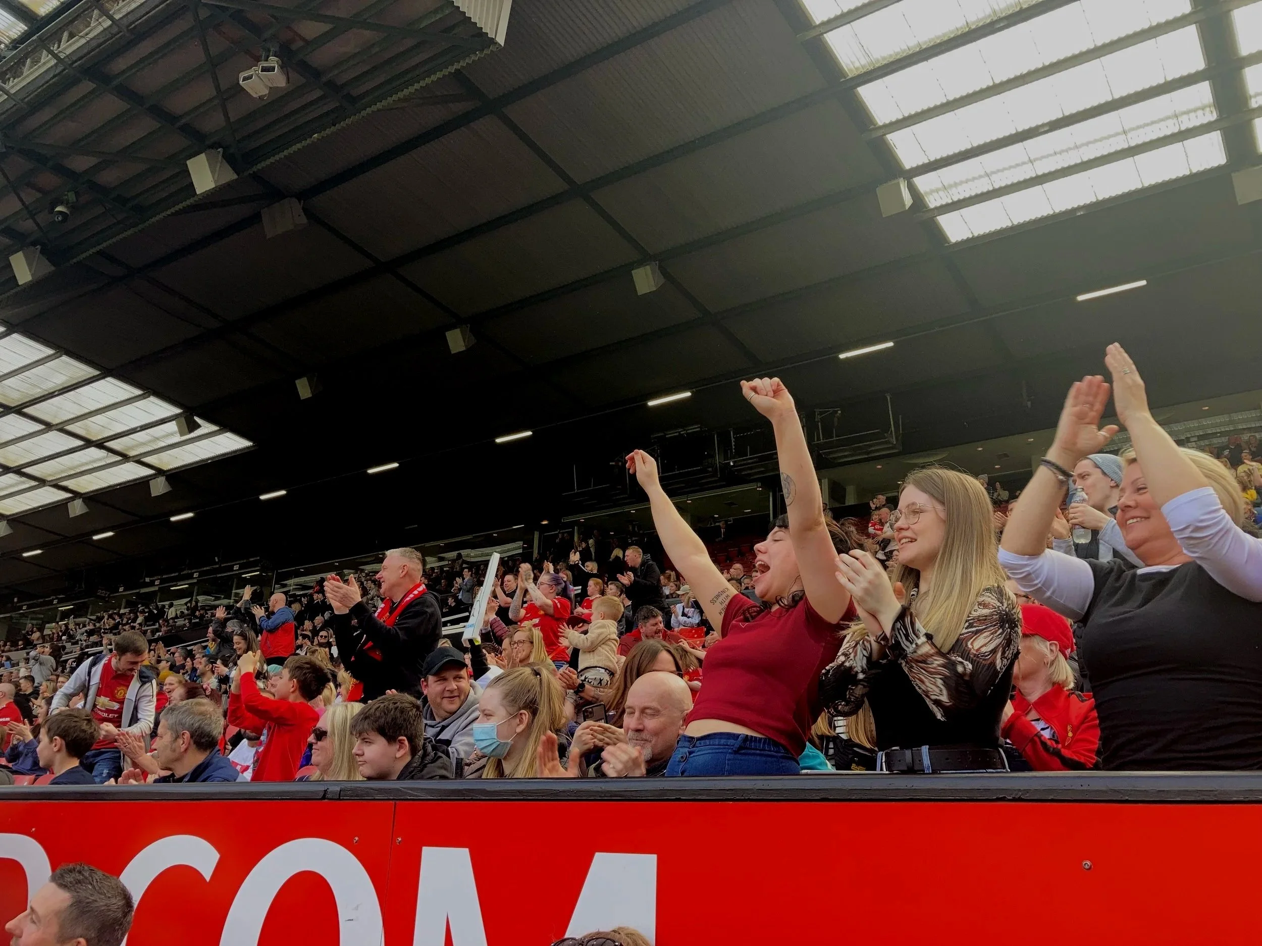 A group of predominately femal fans cheer at a Women's game held Old Trafford