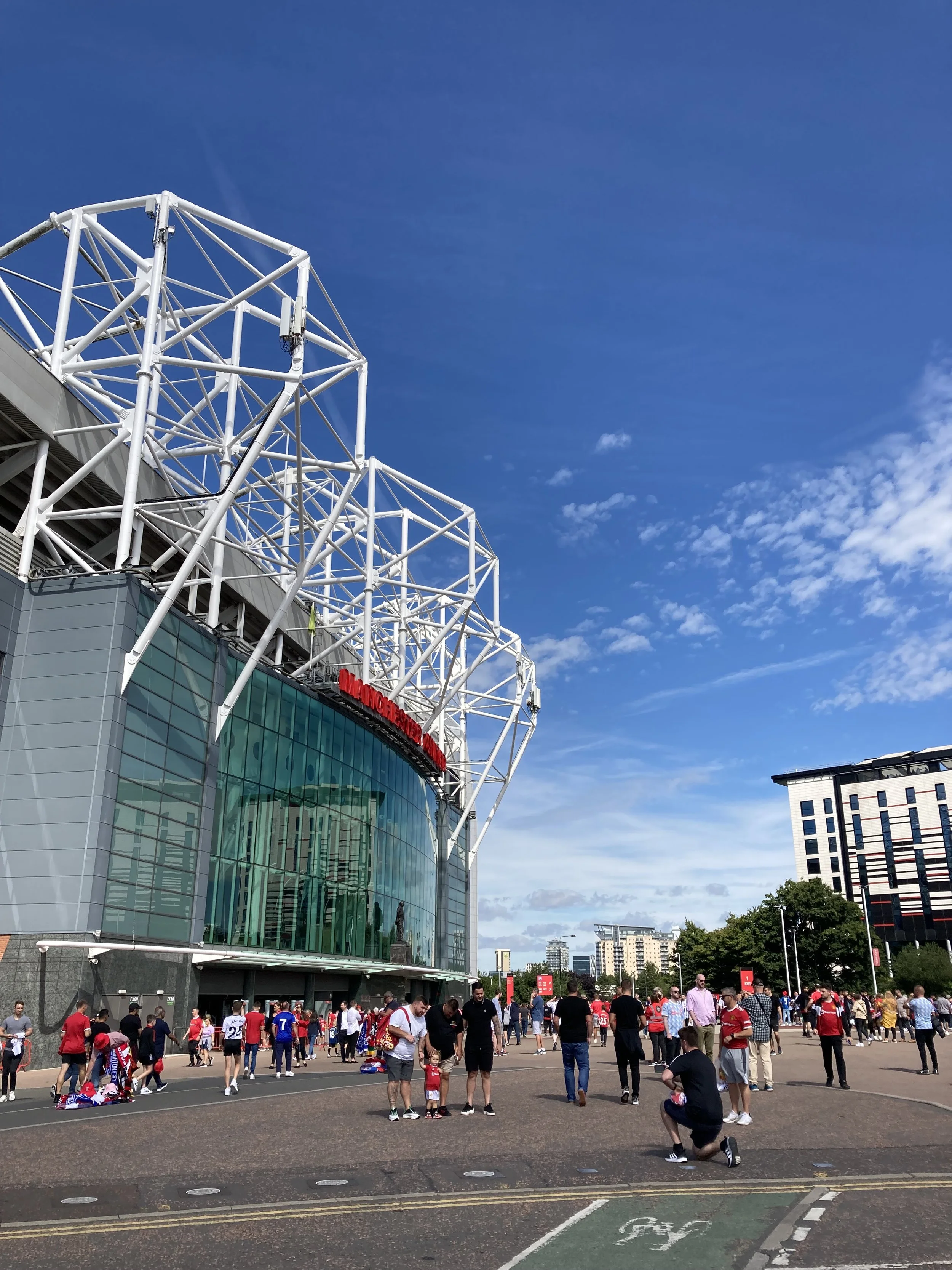 Old Trafford Stadium with a bright blue sky in the background