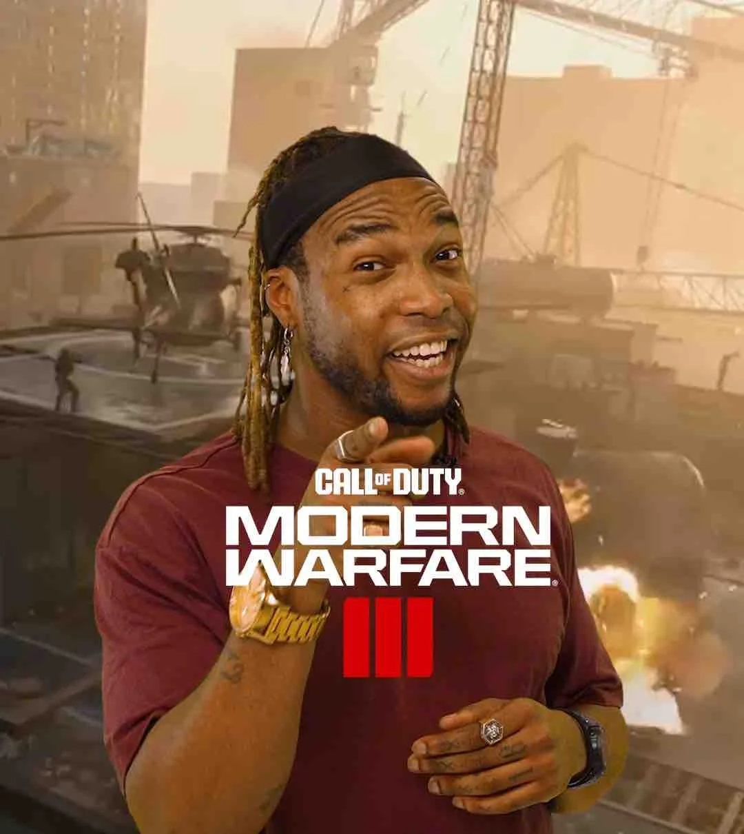 Een man met dreadlocks en een bandana, lachend en wijzend naar de camera, met op de achtergrond een explosie en helikopters in een oorlogssituatie, met de tekst 'Call of Duty Modern Warfare III'.