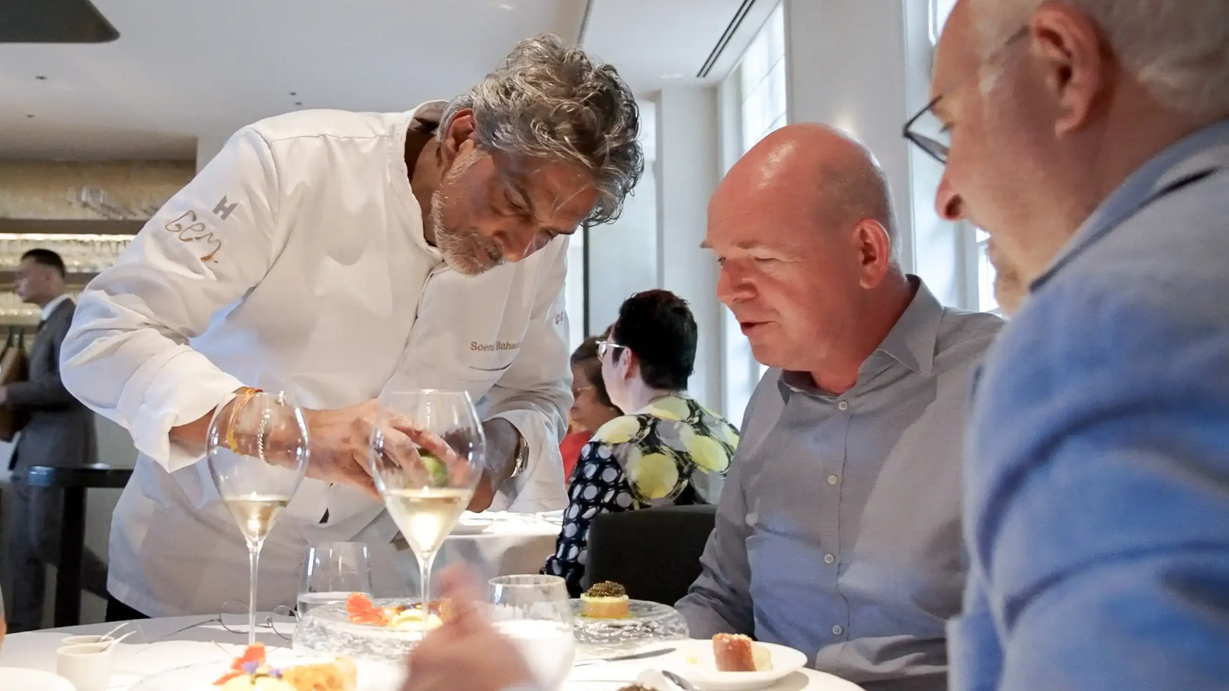 Topchef Soenil Bahadoer die gasten serveert in zijn restaurant, genamd GEM.