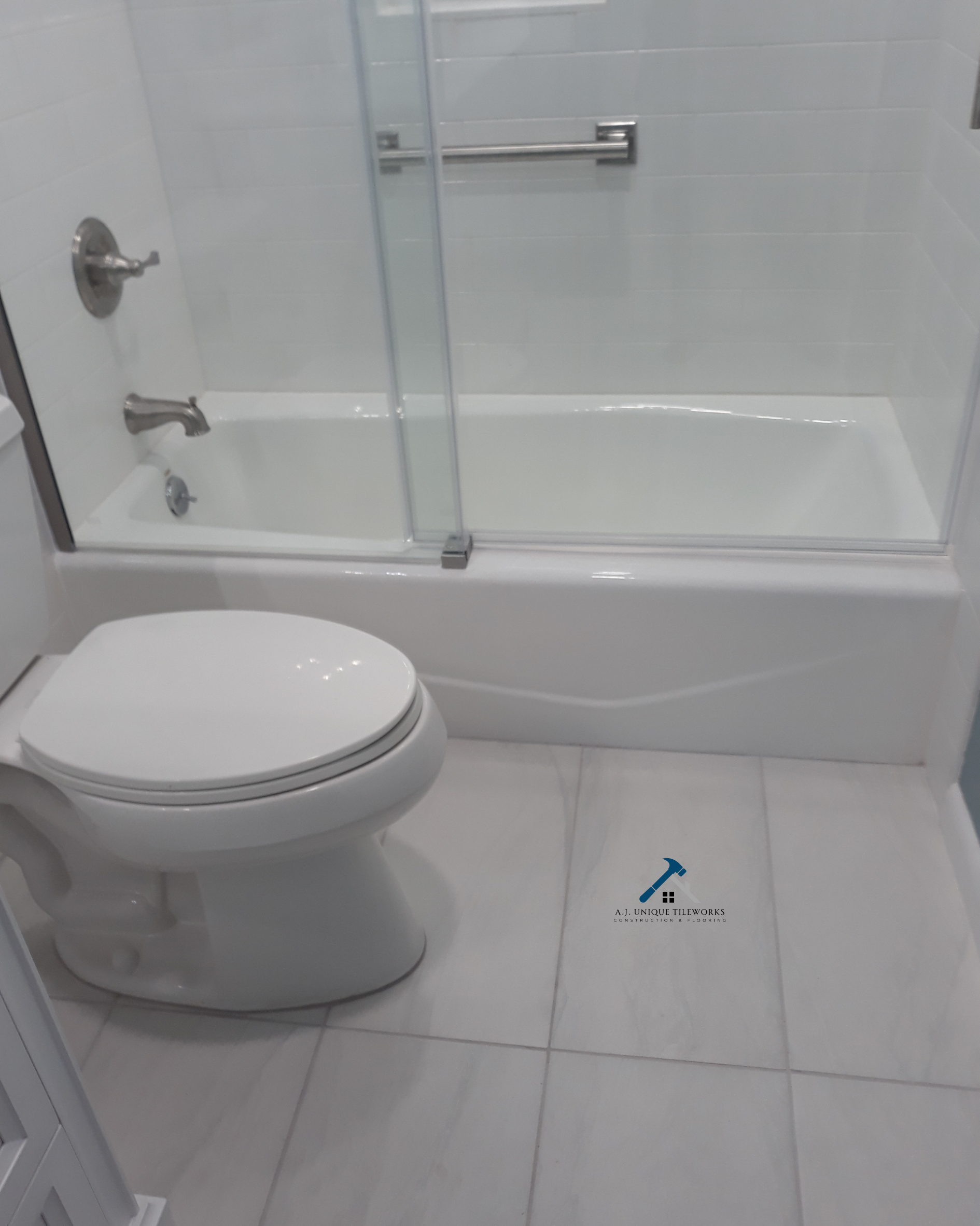 Bathroom with a toilet and a bathtub with glass sliding doors.