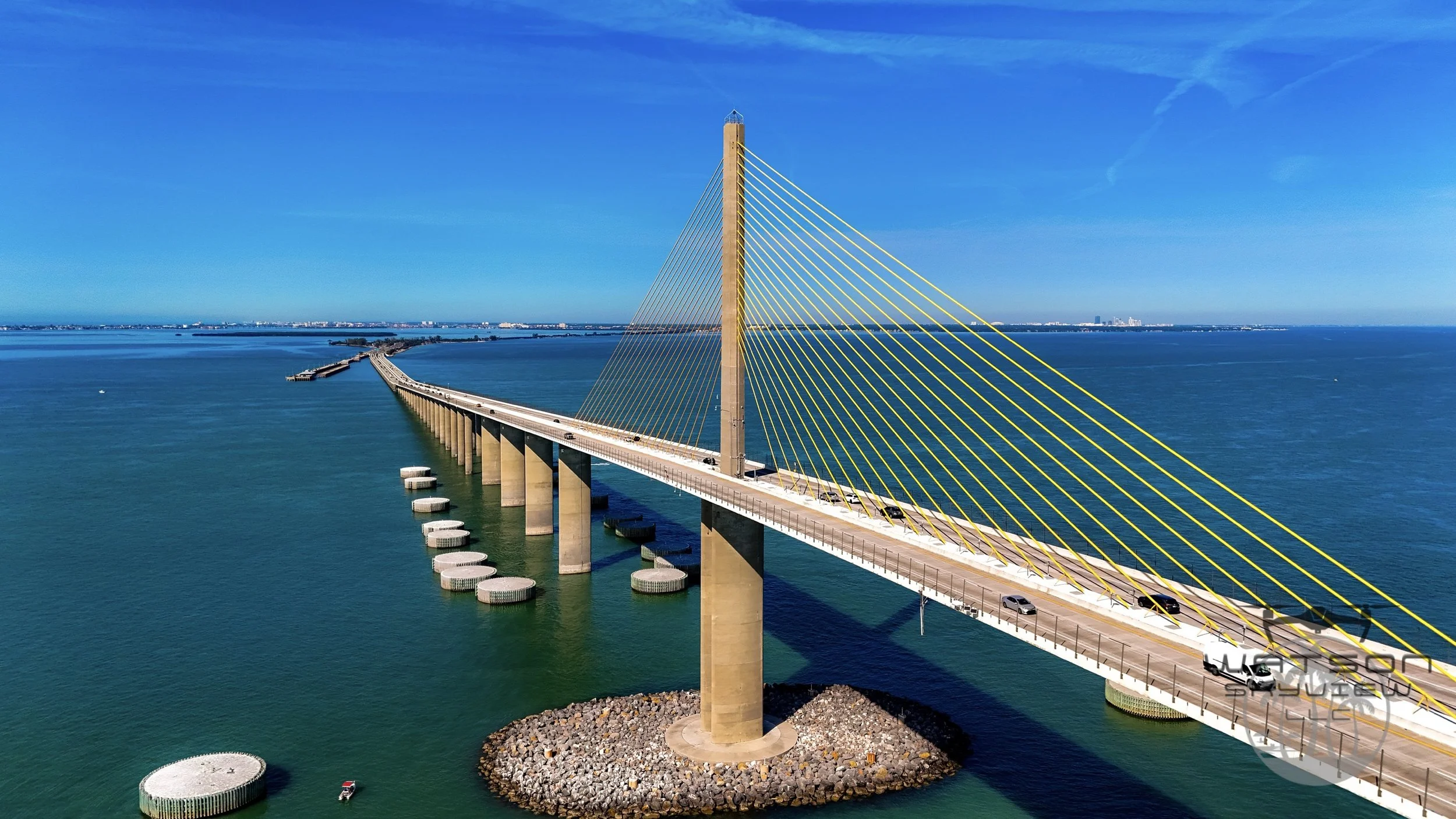 Vibrant sunset sky with colorful clouds over a cityscape, featuring a water tower in the foreground.