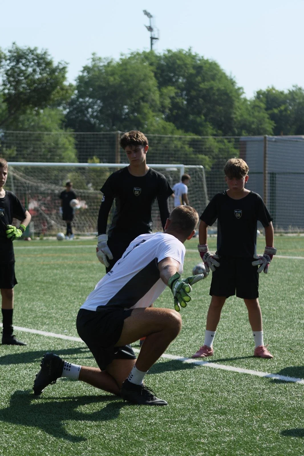 Entrenamiento de fútbol con niños y un entrenador en un campo de césped.