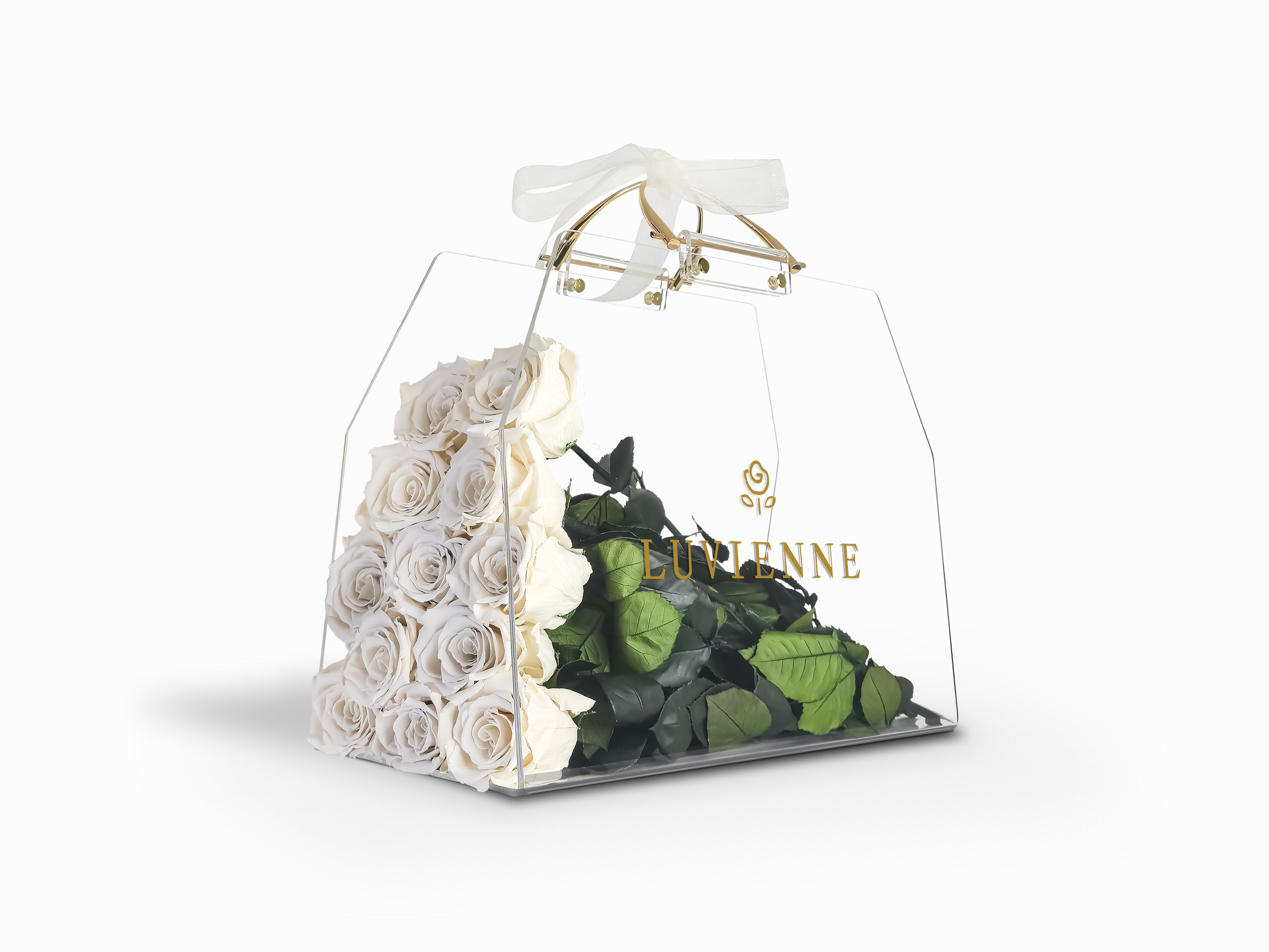 En transparent presentkorg med vita rosor och gröna blad, dekorerad med en vit rosett, med texten 'LUVIENNE' i guld.
