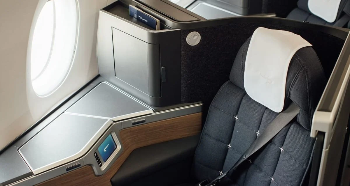 A British Airways business class seat with light streaming in through the window