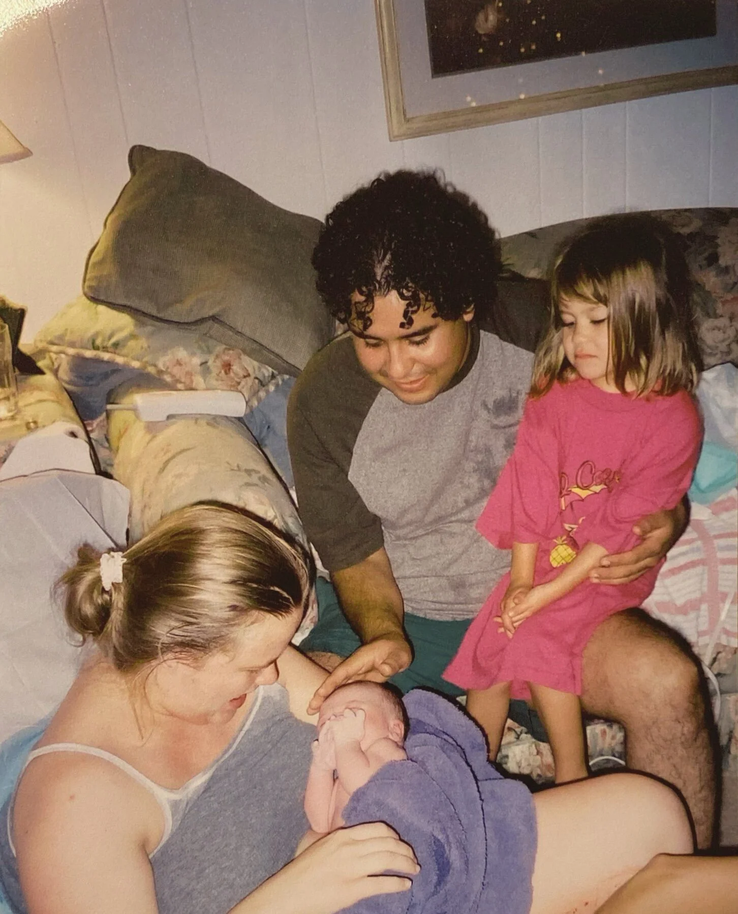 Family in a cozy room, with a woman holding a newborn baby, showing the baby to her family after receving midwifery care in tulsa oklahoma