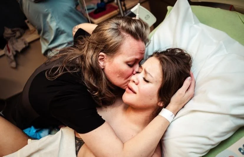 A midwife holding her patient in her arms and lovingly embracing her in oklahoma after an attempted homebirth