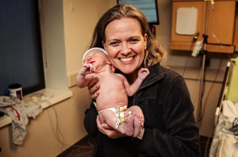 Baby Being Held By Midwife After Receving Midwifery Services