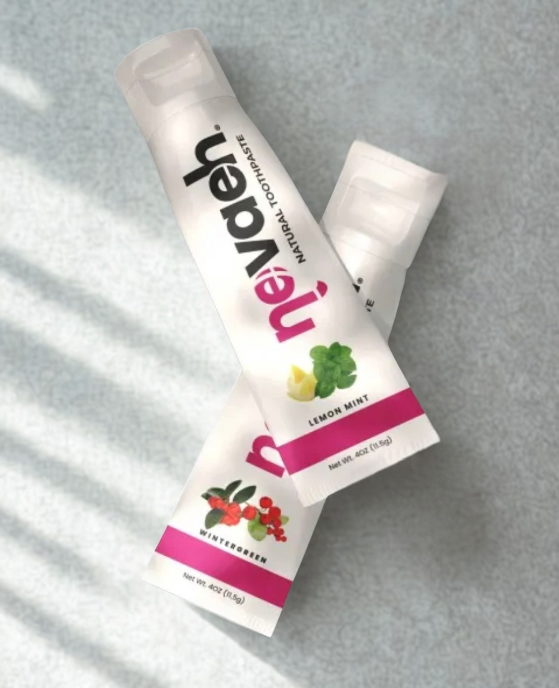 Two tubes of neutrogena natural lip balm, one labeled lemon mint and the other wintergreen, placed on a light-colored surface.