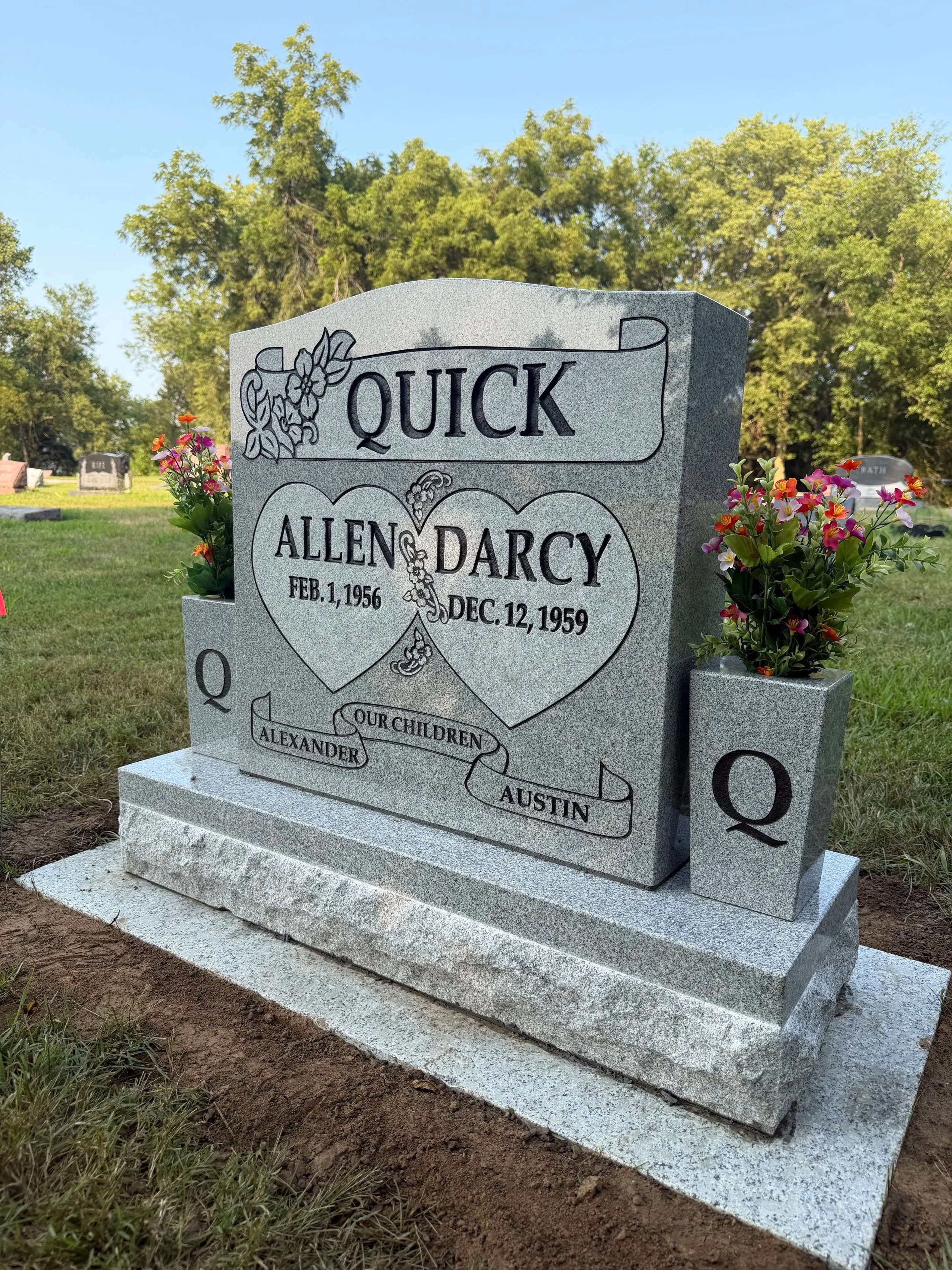 Gray granite upright headstone with personalized engraving, set in a peaceful rural Iowa cemetery