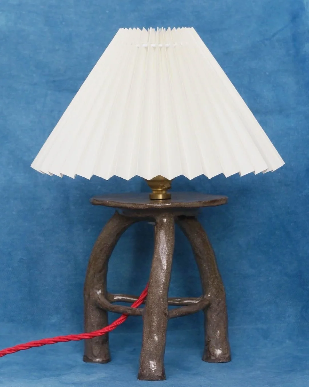 Banquito Lamp

Made by Benedetta Ficarelli in Hackney London the Banquito Lamp is hand built in vulcan black stoneware and paired with a pleated lampshade. The piece brings together a solid ceramic base and a soft diffused light. 

Now available made