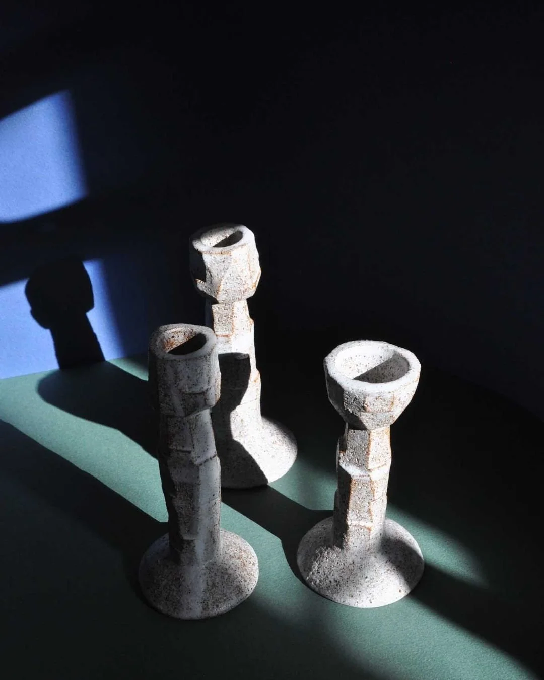 Hand built in white chamotte sandstone, this candle holder is made by Gabriela Bins in Lisbon, Portugal. Finished in a matte white glaze, the surface reveals the texture of the clay and the marks of cutting and shaping. Its elevated, sculptural form 