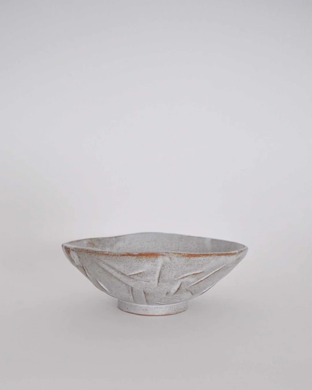 Hand built in chamote light brown sandstone clay, this bowl is made by Gabriela Bins in Lisbon, Portugal. Finished in a matte white glaze, the surface reveals the texture of the clay and the marks of cutting and shaping. 

Now available at craftersof