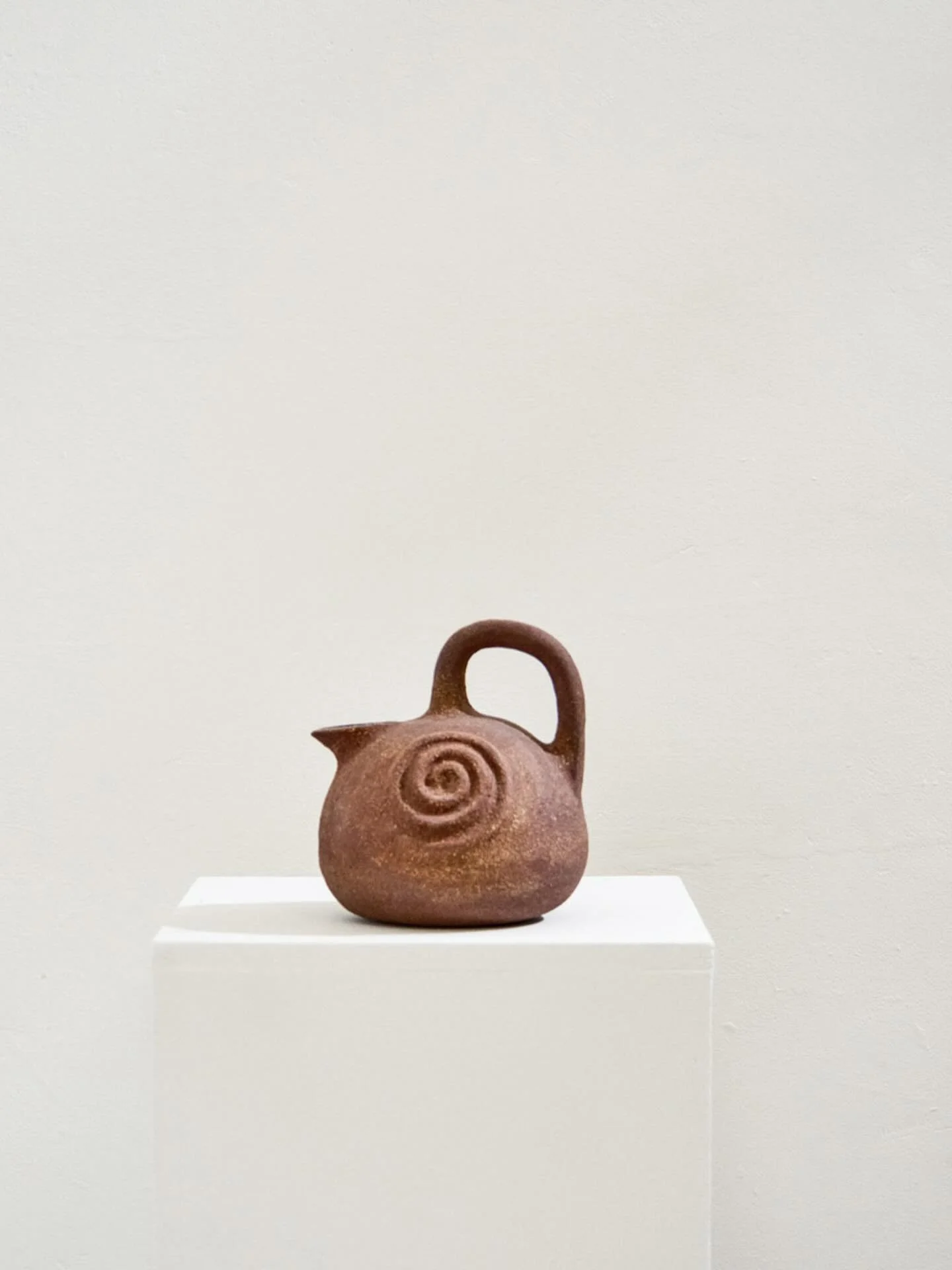 Handbuilt using the coiling and pinching technique, the Spiral Pitcher is made by Lou Thomas in her Marseille studio. Crafted in red stoneware with a glossy transparent glaze inside and left unglazed outside, the piece highlights the raw, earthy text
