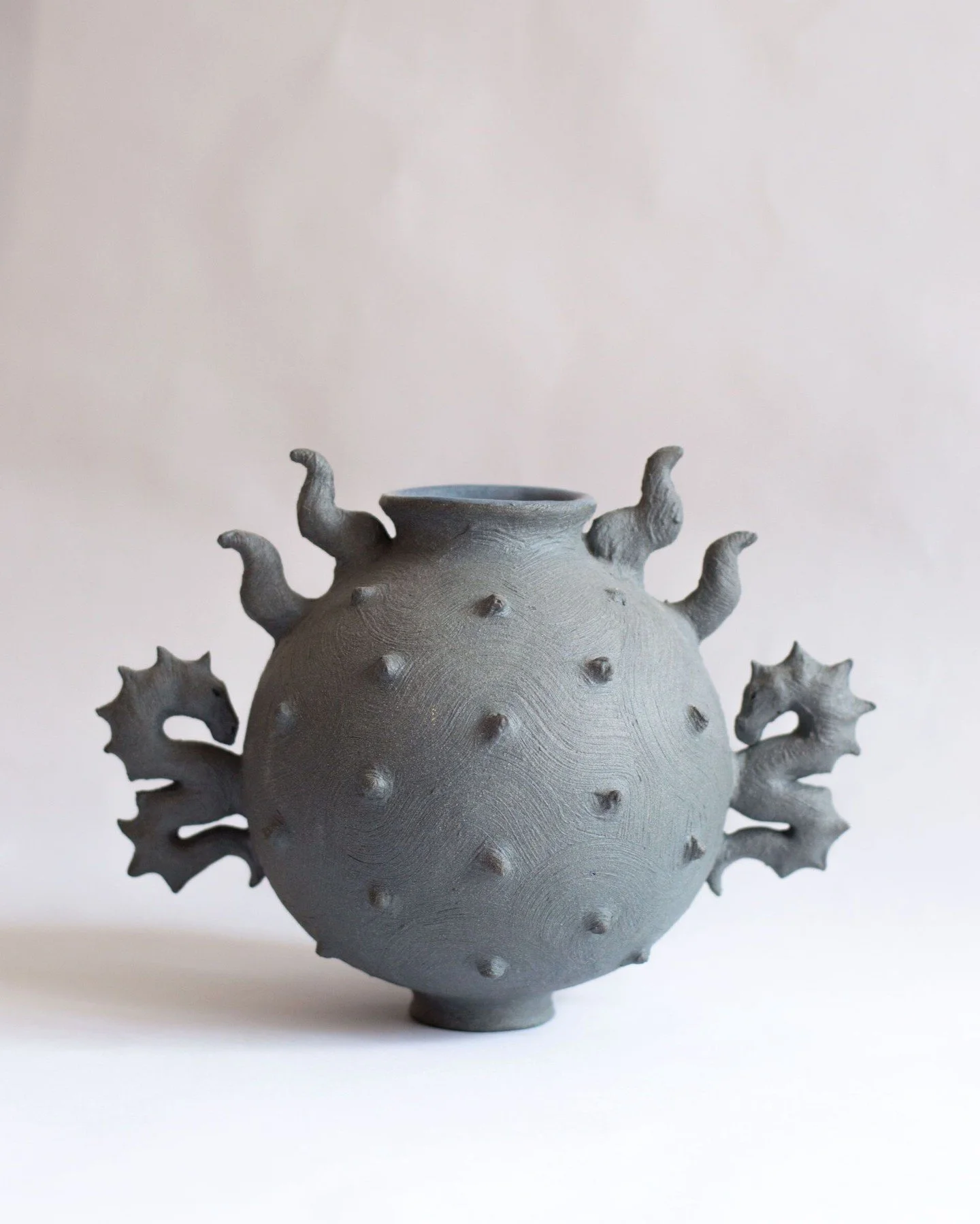 Cyriopa Vessel is wheel thrown and hand sculpted by Ioulia Chante in Malta. Made in pigmented cobalt stoneware, the piece is formed as a single body and semi burnished with a brush, and carries surreal, arachnoid features. Selected areas are glazed a