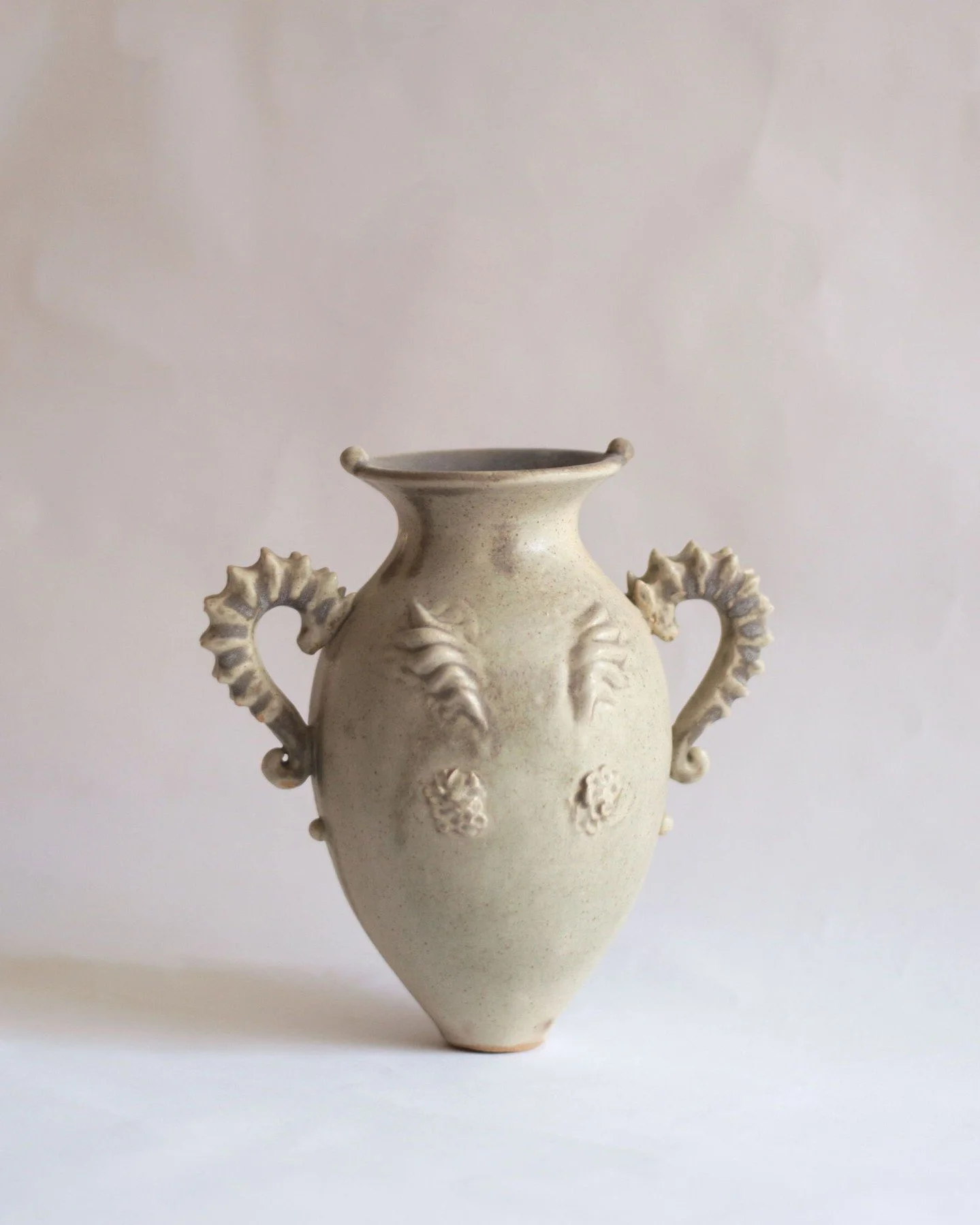 Estuary Amphora is wheel thrown and hand sculpted by Ioulia Chante in Malta. Made in white stoneware, the amphora form is complemented by handles shaped as seahorses, drawing from the flowing elements and creatures of reefs and rivers. Finished in a 