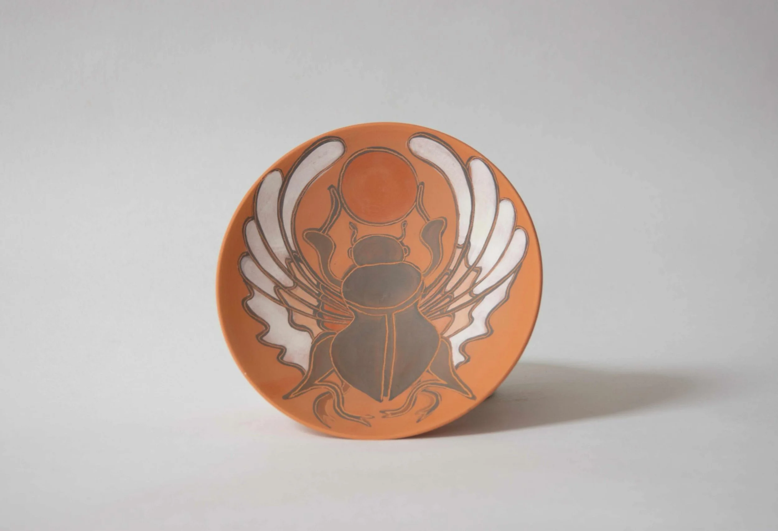Scarab Ceramic Bowl is wheel thrown in stoneware and decorated with terra sigillata. Created collaboratively by Maud Timmermans and Samantha Thole, each wall bowl combines hand applied imagery and ceramic forms designed for display.

Part of our sele