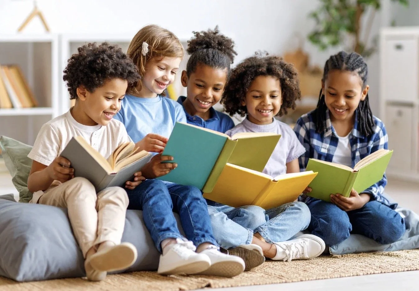 Six smiling children sitting on a rug indoors, reading colorful books together.
